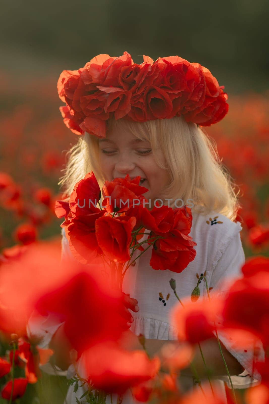 A young girl is standing in a field of red flowers, wearing a red flower crown. She is holding a red flower in her hand and she is enjoying the beauty of the flowers. Concept of innocence and wonder