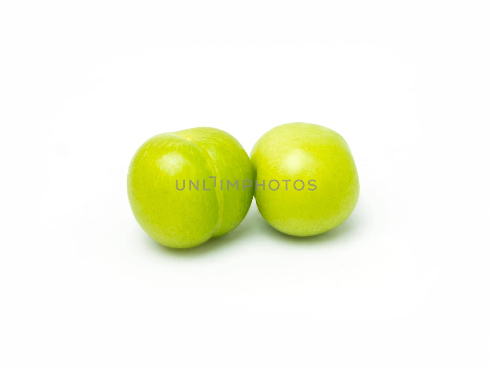 pair of fresh green plums isolated on white background. High quality photo