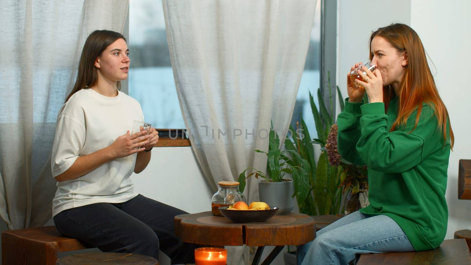 Young women drink tea and have fun chatting in cafe. Media. Young students are having fun talking in cozy college cafe. Women drink tea and laugh in cafe by Mediawhalestock