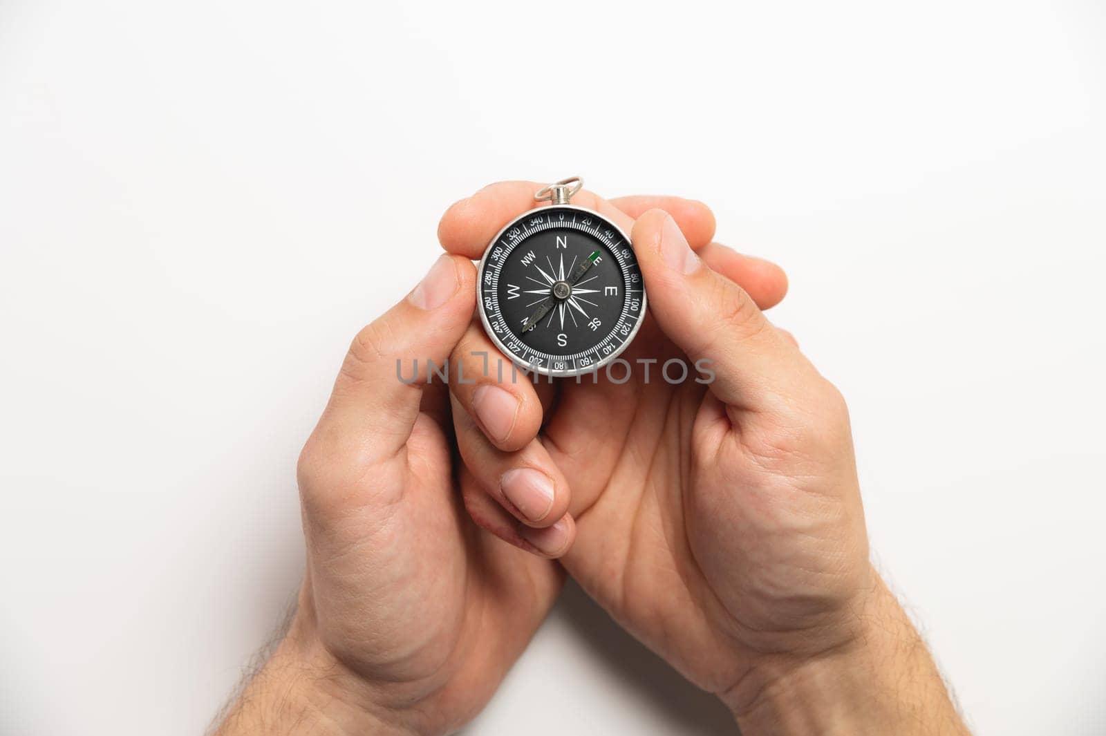 compass in hands on a white background close-up. male hands hold modern compass in retro style by yanik88