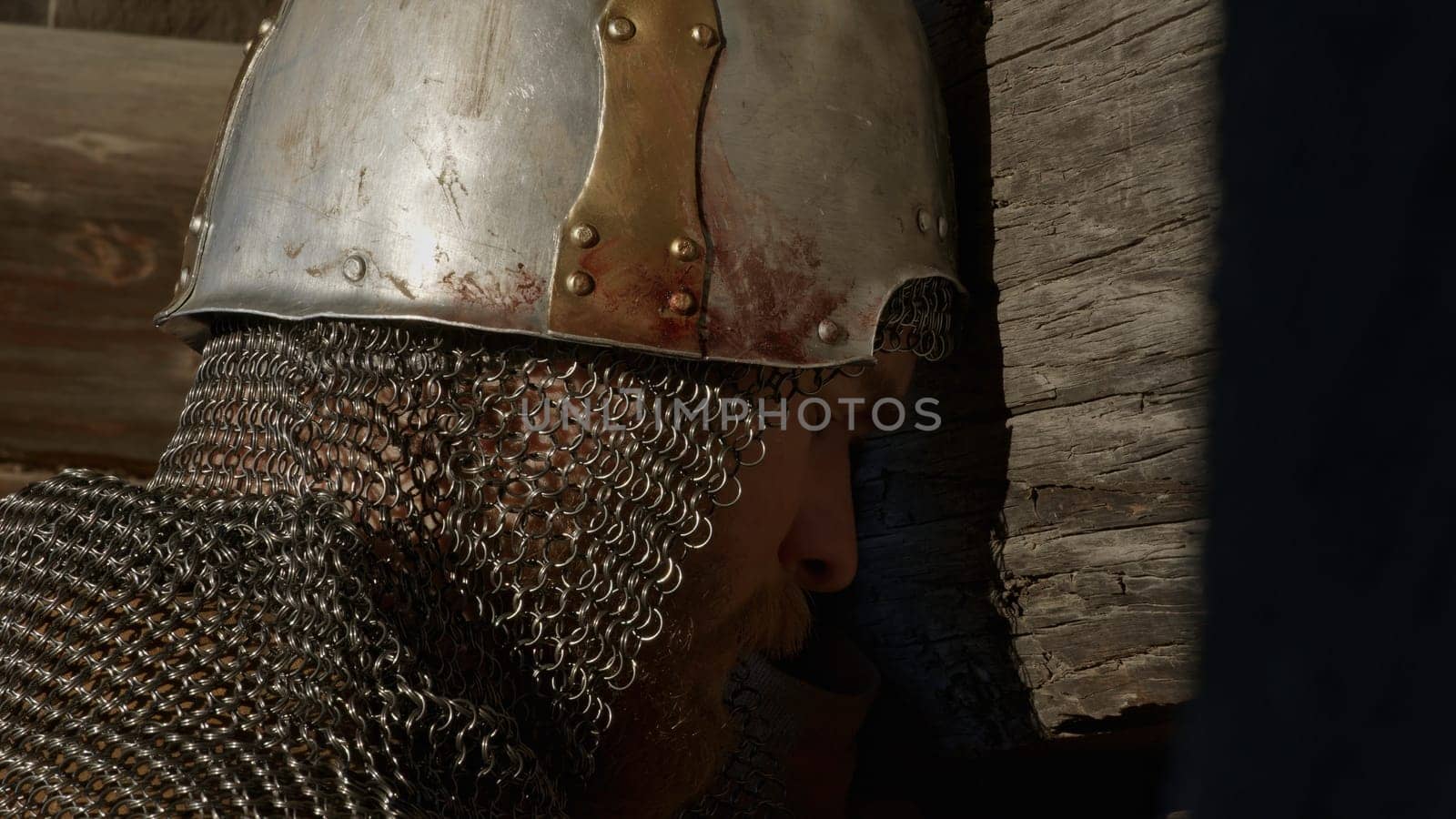 Medieval old knight helmet and chain mail for protection in battle. Media. Close up side view of a man in very heavy headdress, middle ages armor concept