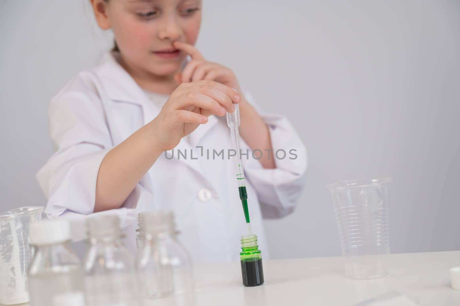 Caucasian girl doing chemical experiments on a white background. by mrwed54