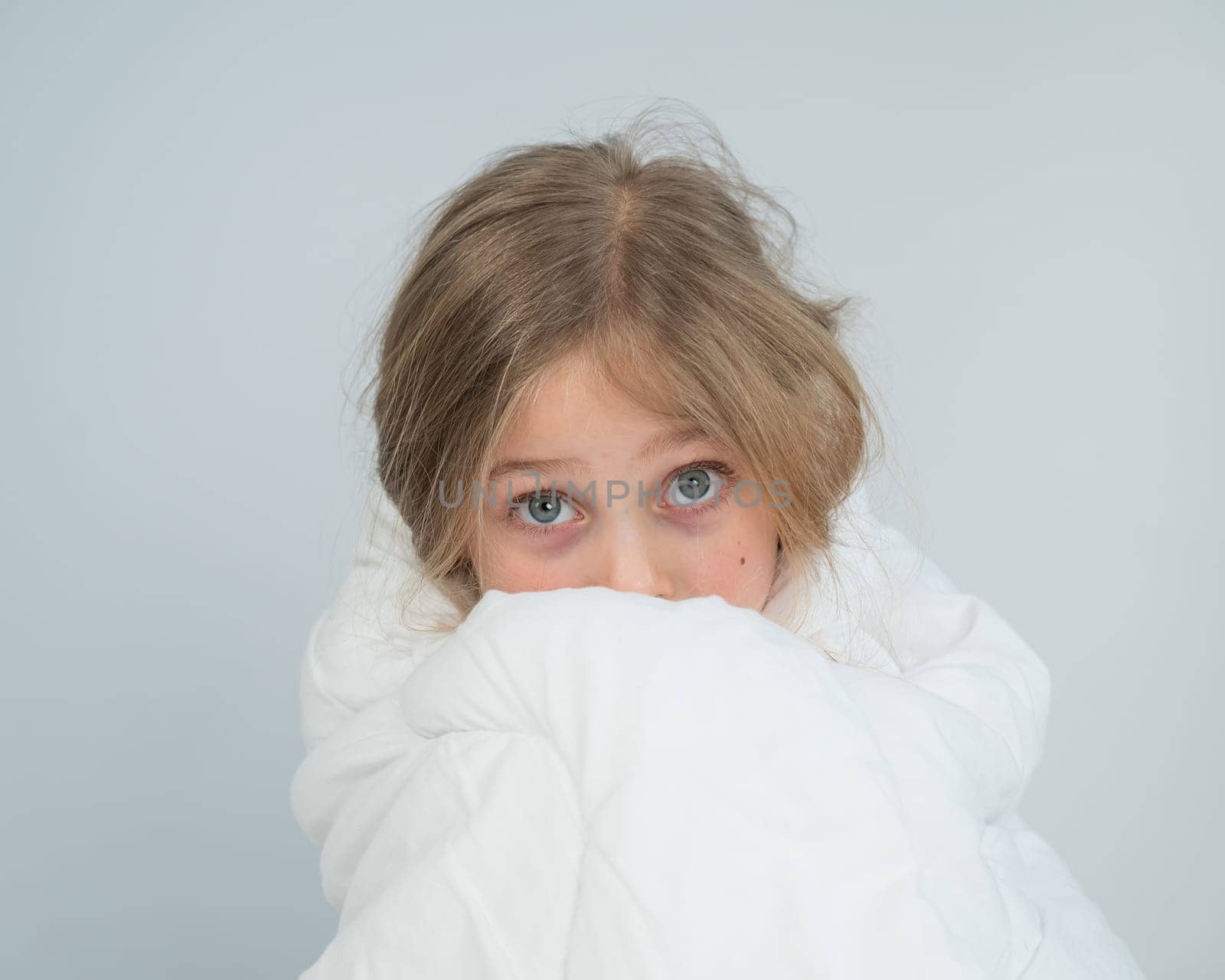 Portrait of a cute little girl wrapped in a white blanket. by mrwed54
