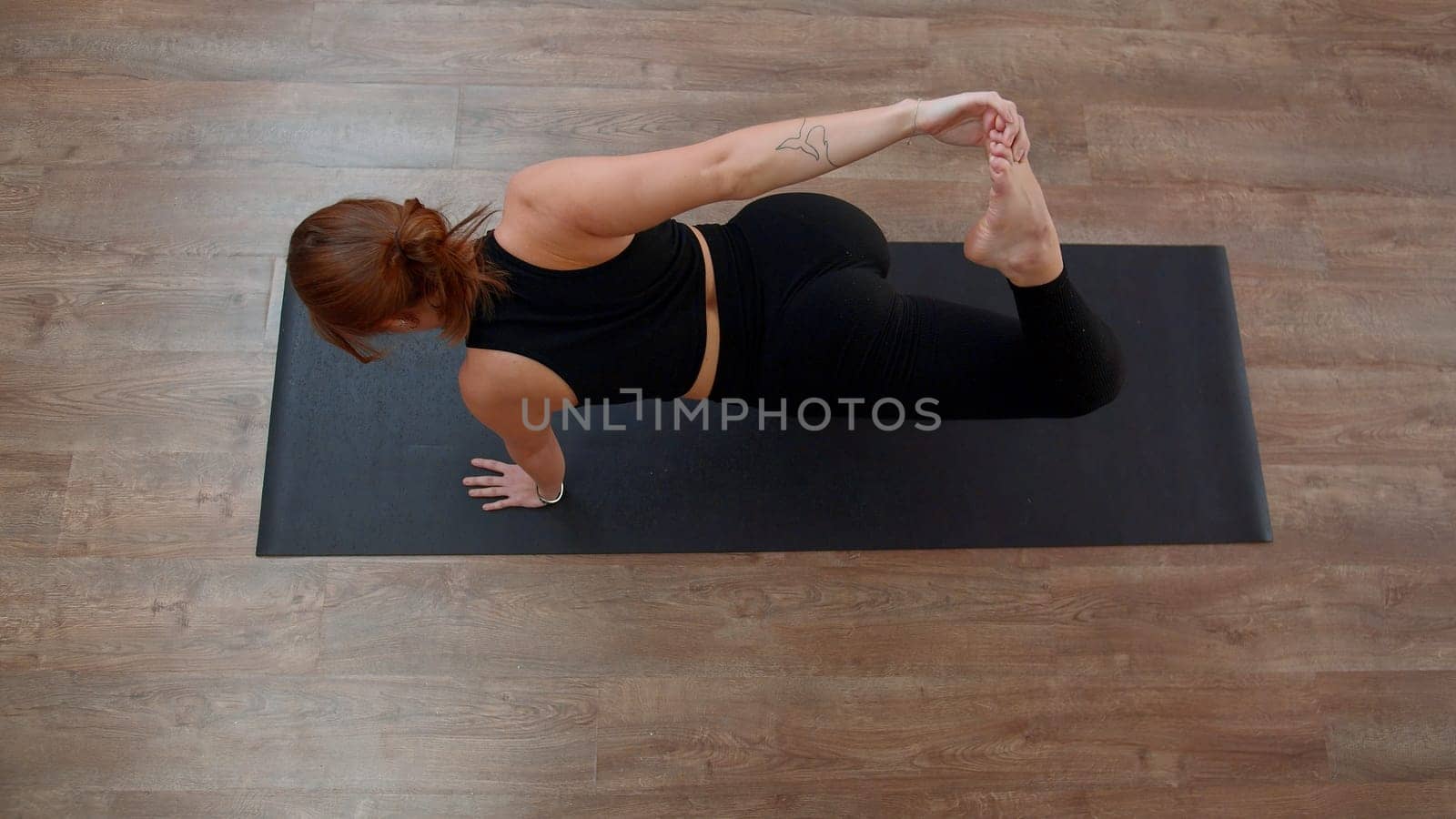 Beautiful Caucasian woman doing fitness on mat at home. Media. Top view of a girl performing exercises