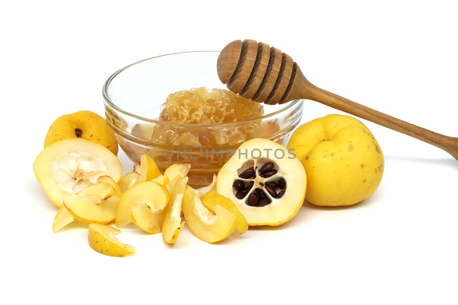 Glass with honey surrounded by vibrant quince fruits, both sliced and whole isolated on white background, full depth of field