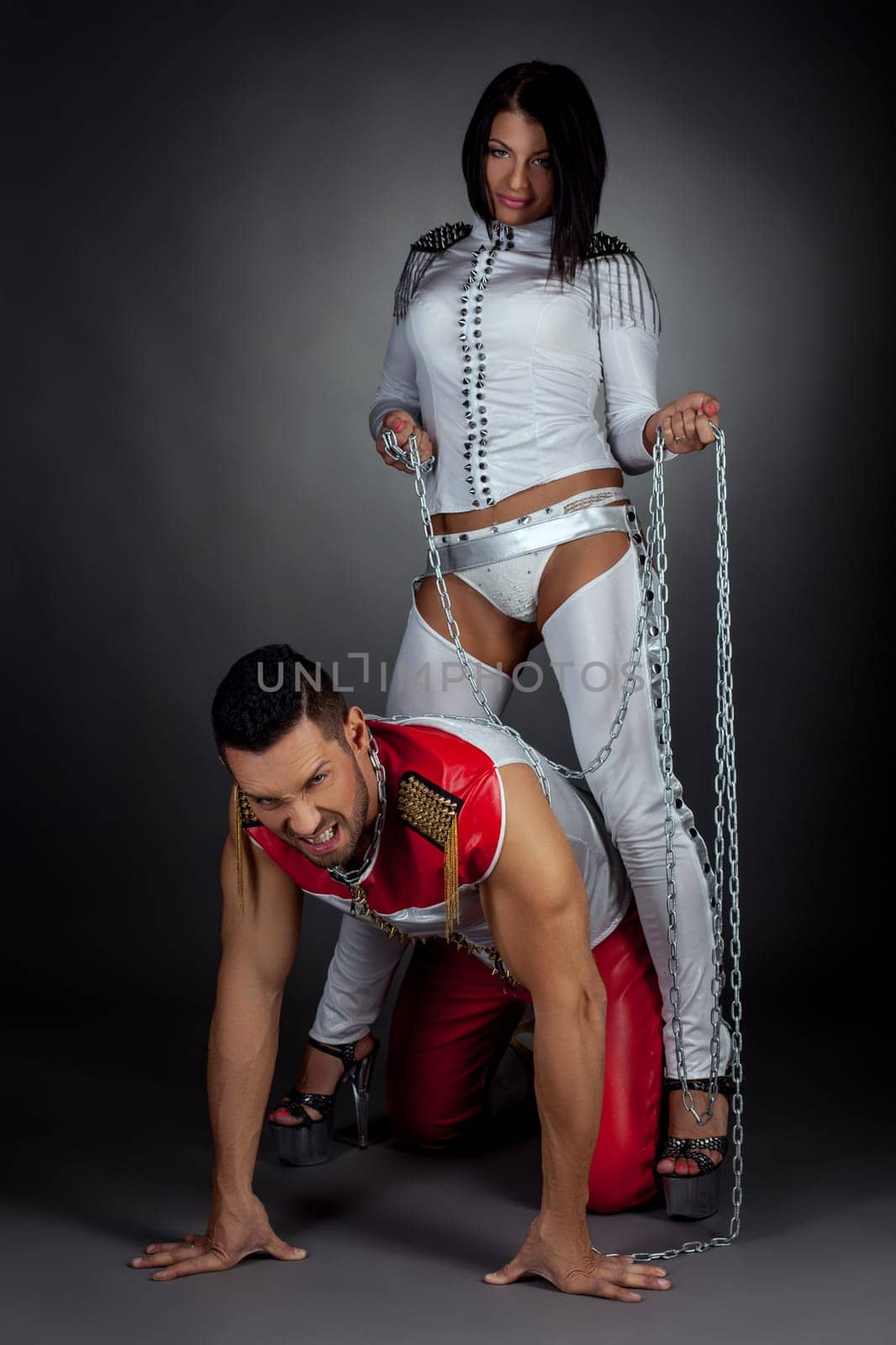 Couple of dance show. Imperious woman and guy in chains