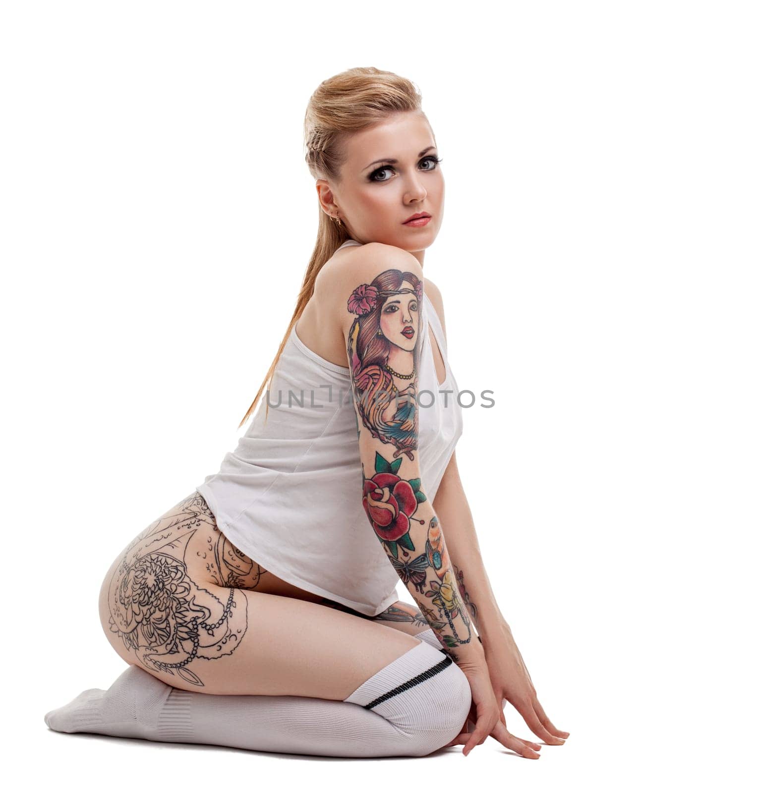 Studio image of pretty young woman with tattooed body. Isolated on white