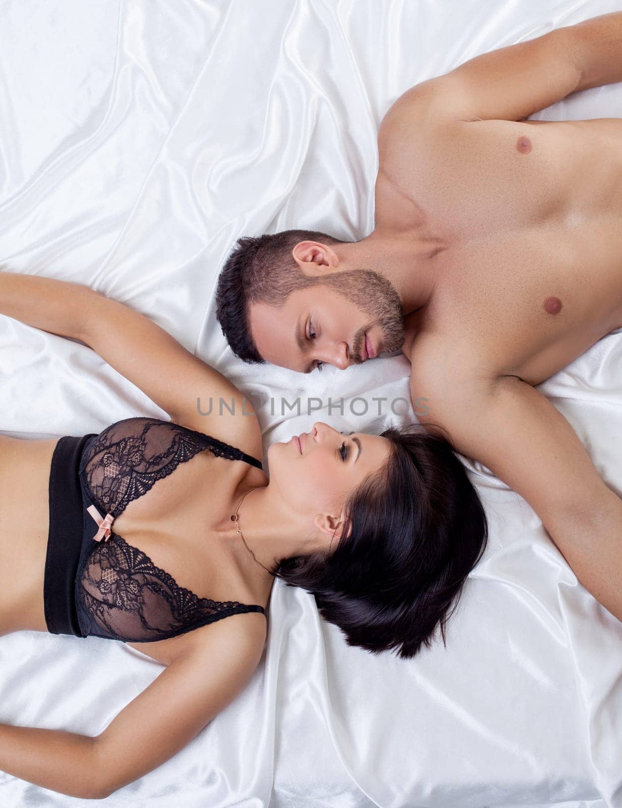 Love and sex. Top view of beautiful loving couple lying in bed