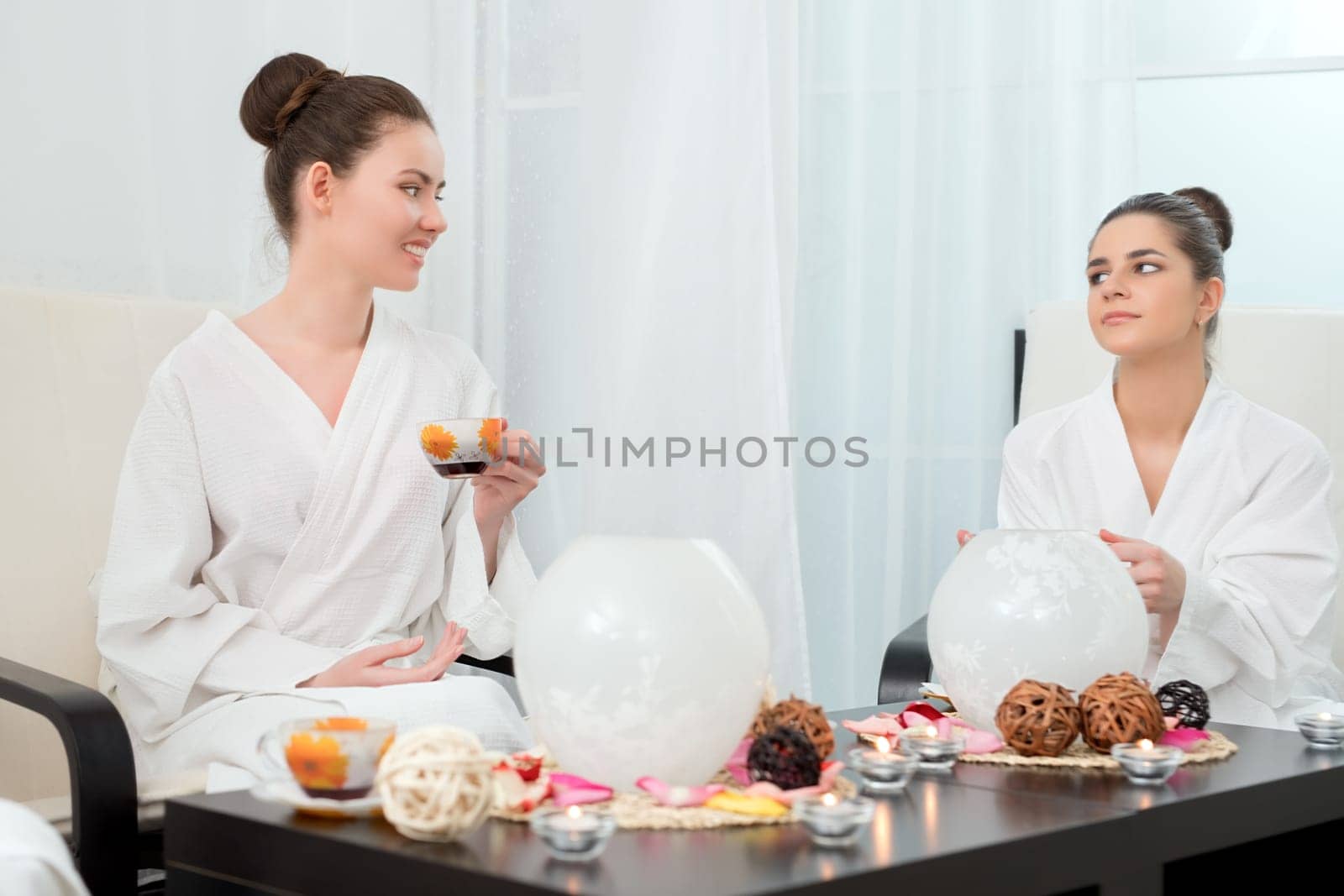 Photo of lovely girls drinking tea in beauty salon