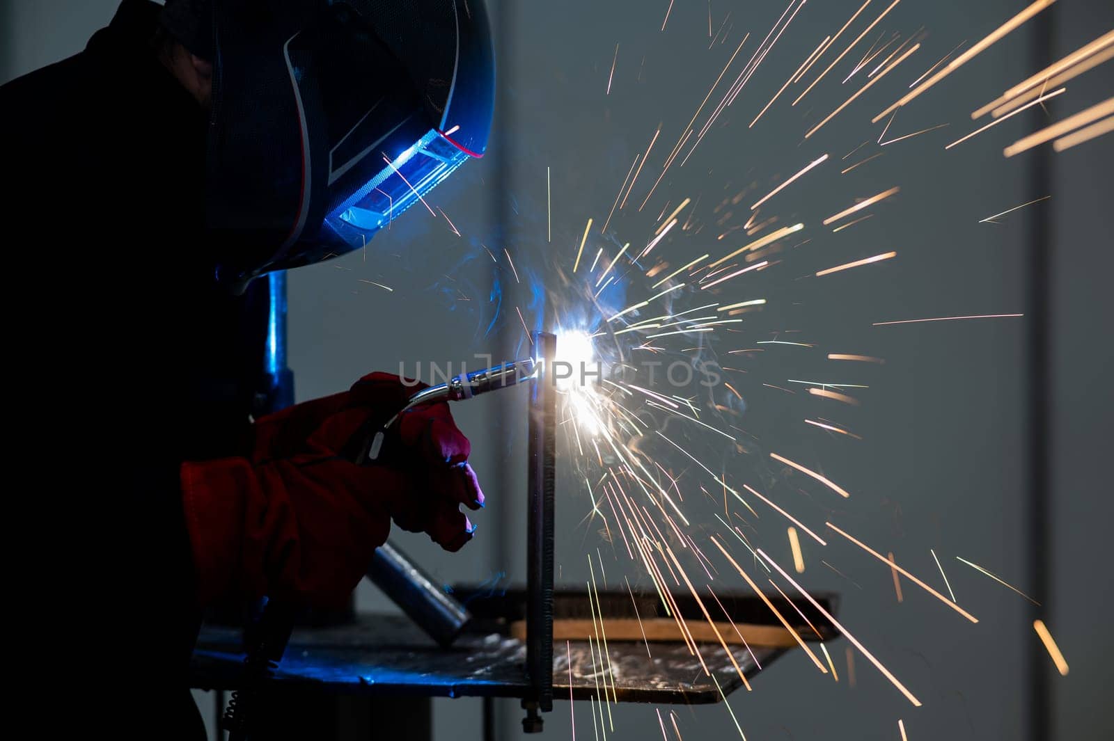 A man learns the craft of welding on a sample