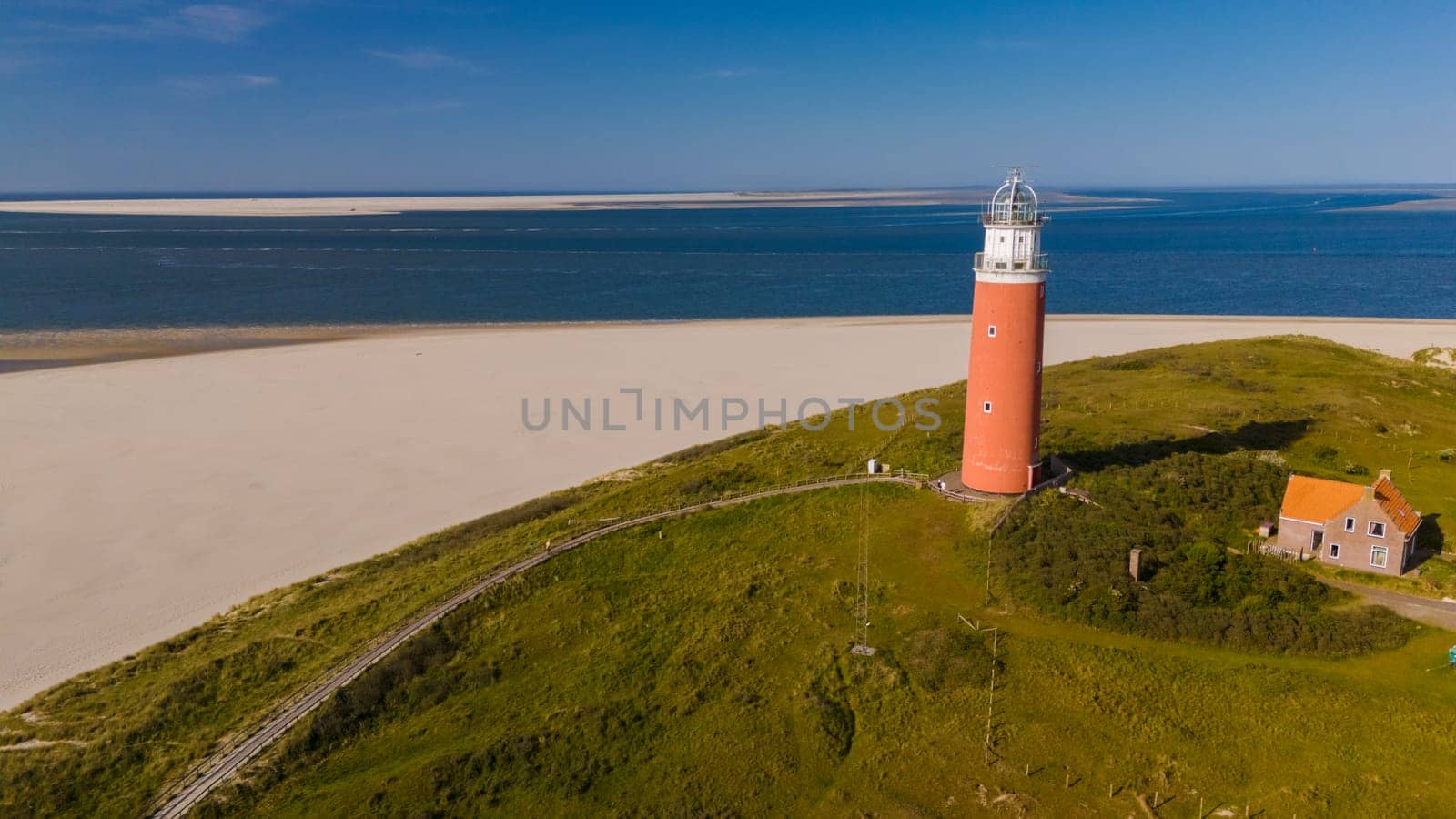 A solitary lighthouse stands tall on the sandy shores of Texel, guiding ships with its beacon of light and adding a touch of enchantment to the coastal landscape.