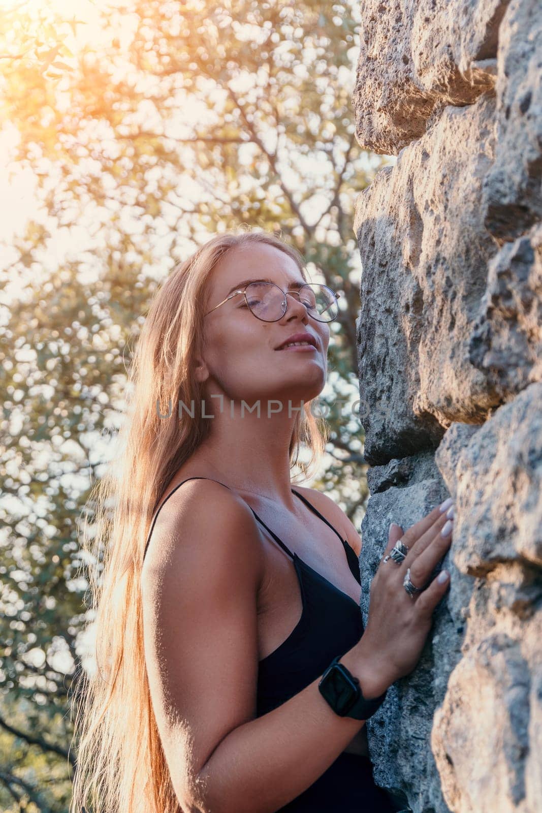 Woman travel sea. Young Happy woman in a long red dress posing on a beach near the sea on background of volcanic rocks, like in Iceland, sharing travel adventure journey