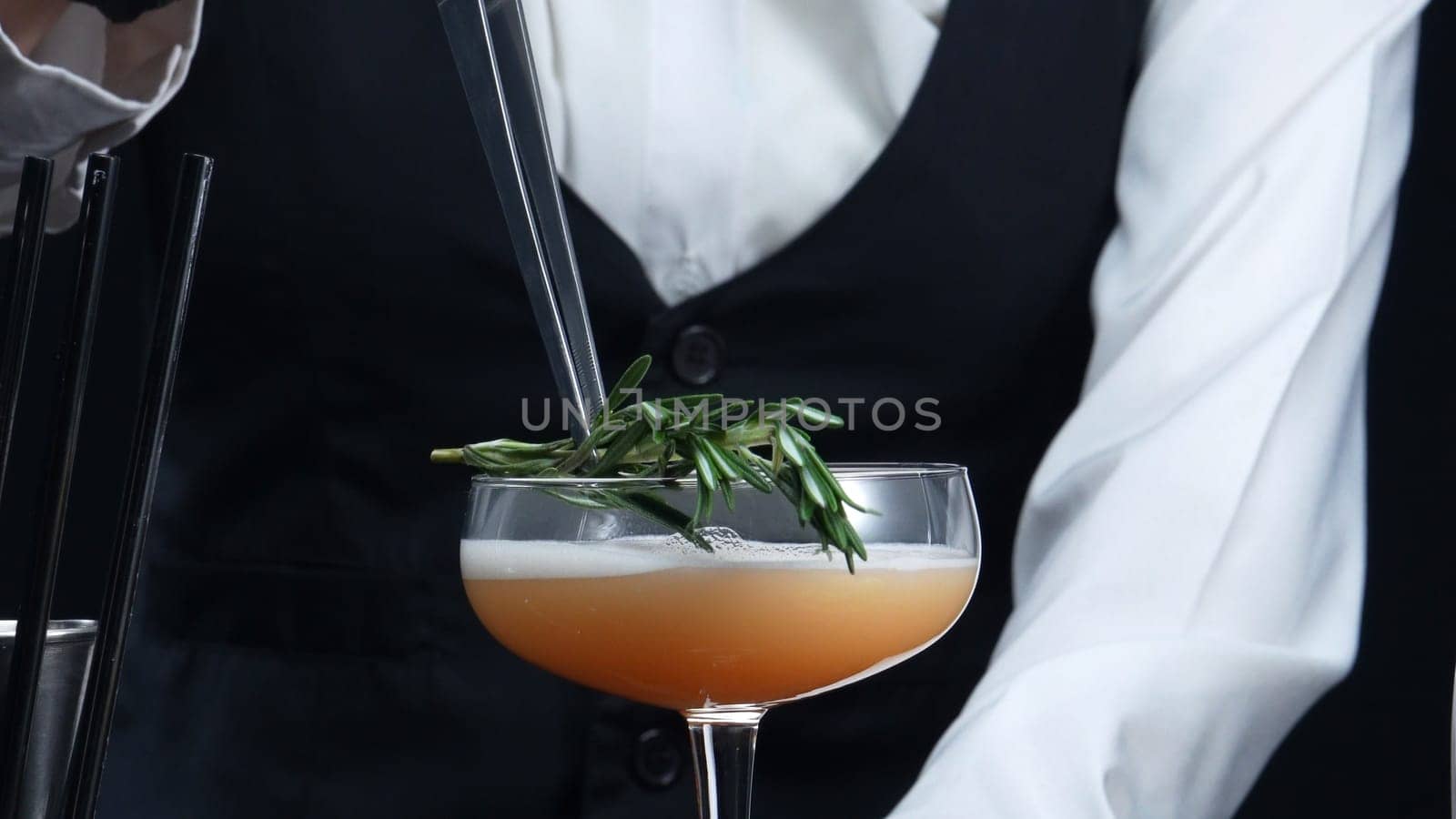 Close up of bartender prepare cocktail with orange and rosemary. Comestible. by biancoblue