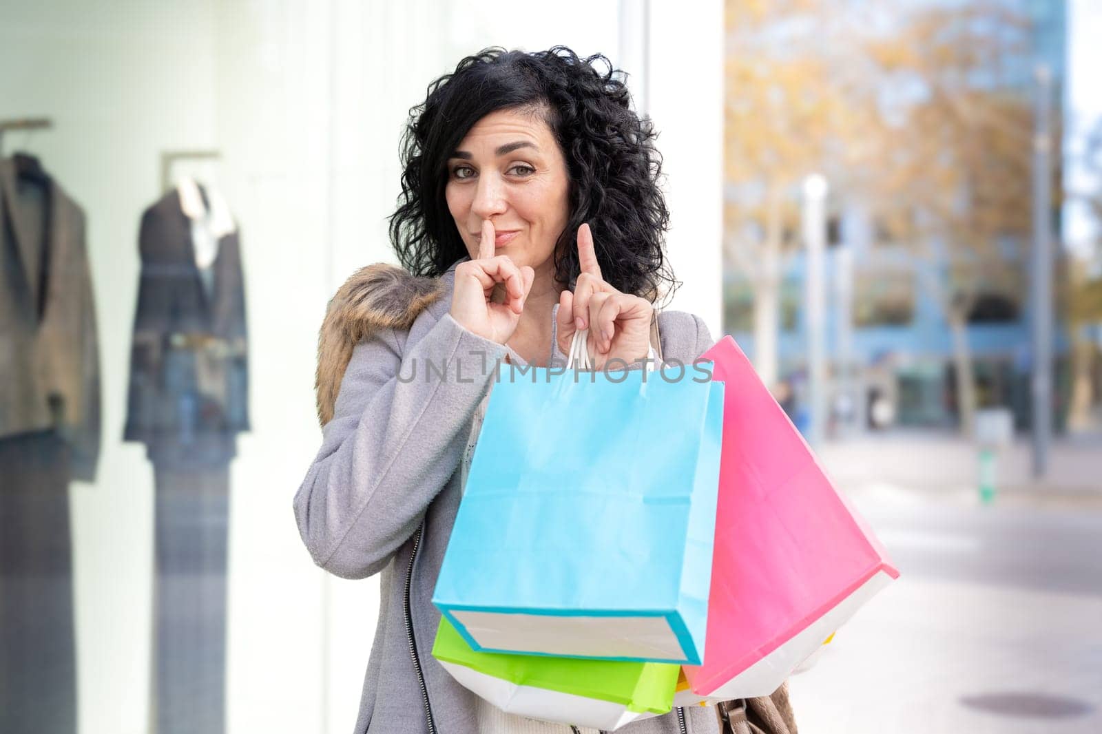 Woman shopping. Woman with shopping bags with defiant gesture. Consumerism, shopping, lifestyle concept