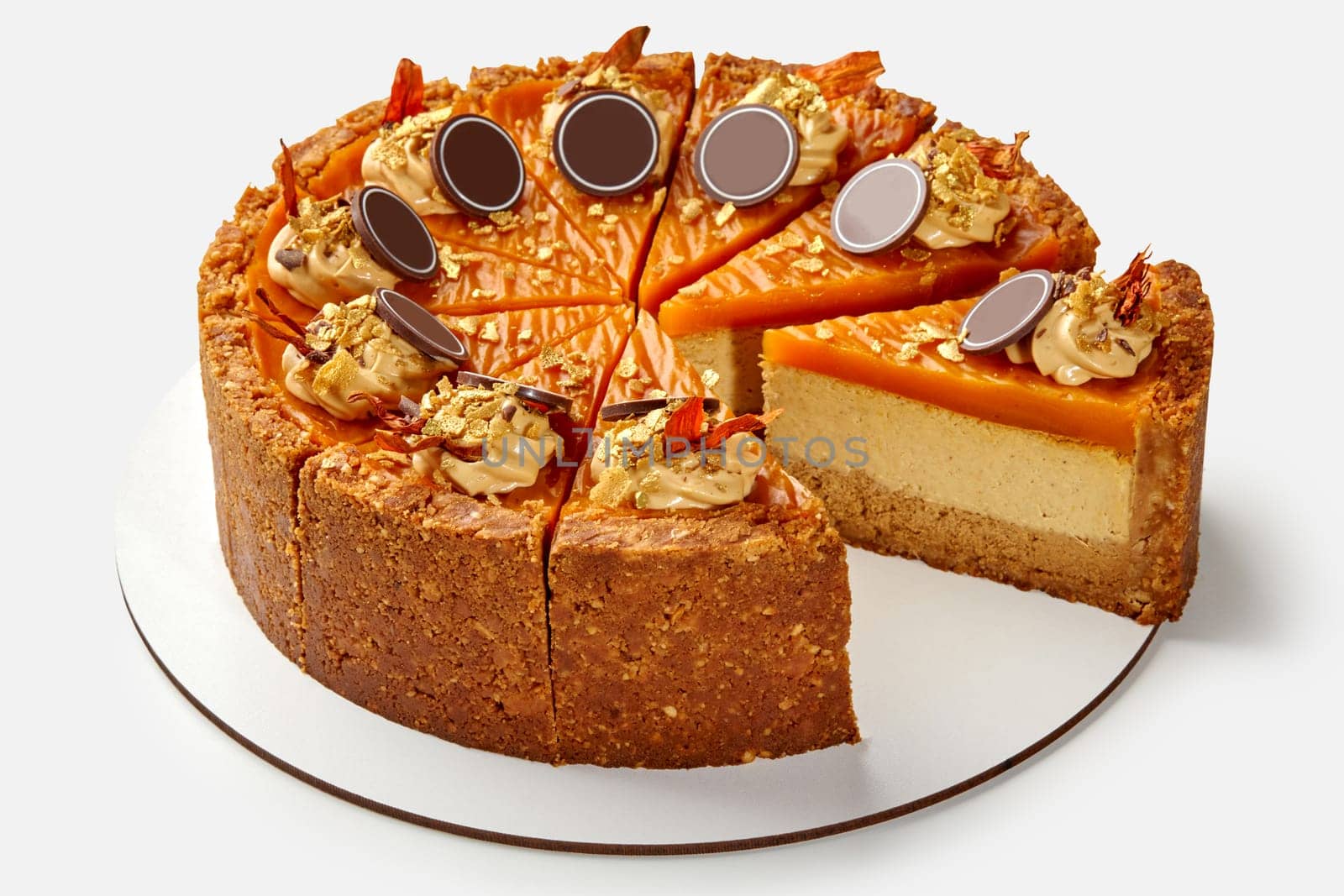 Sliced delicious cheesecake with crunchy shortcrust base topped with tender pumpkin jelly layer decorated with nut whipped cream, caramel crumbs and chocolate. Welcome fall with seasonal dessert