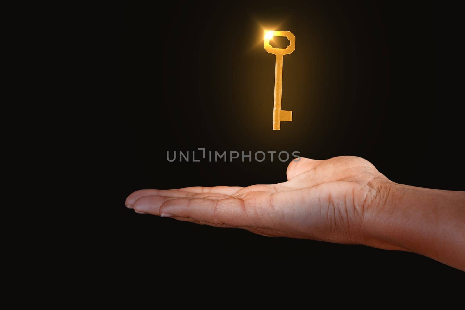 Close up of hand showing key to success isolated on black background