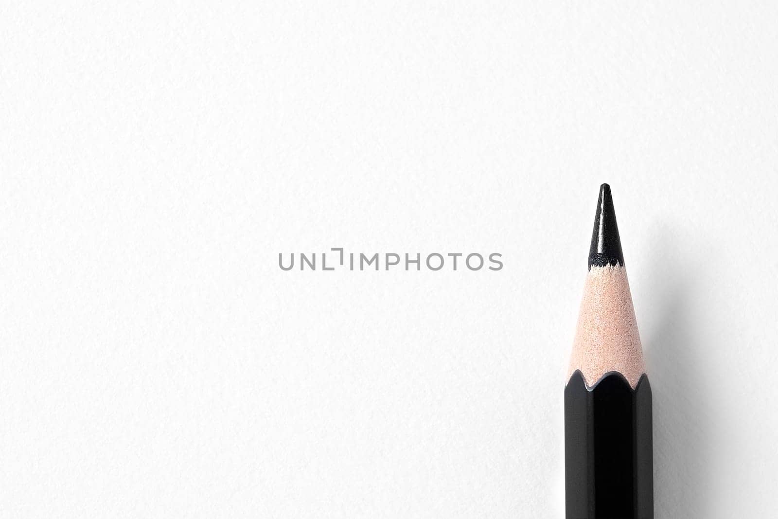 Black pencil on white paper texture background, copy space.