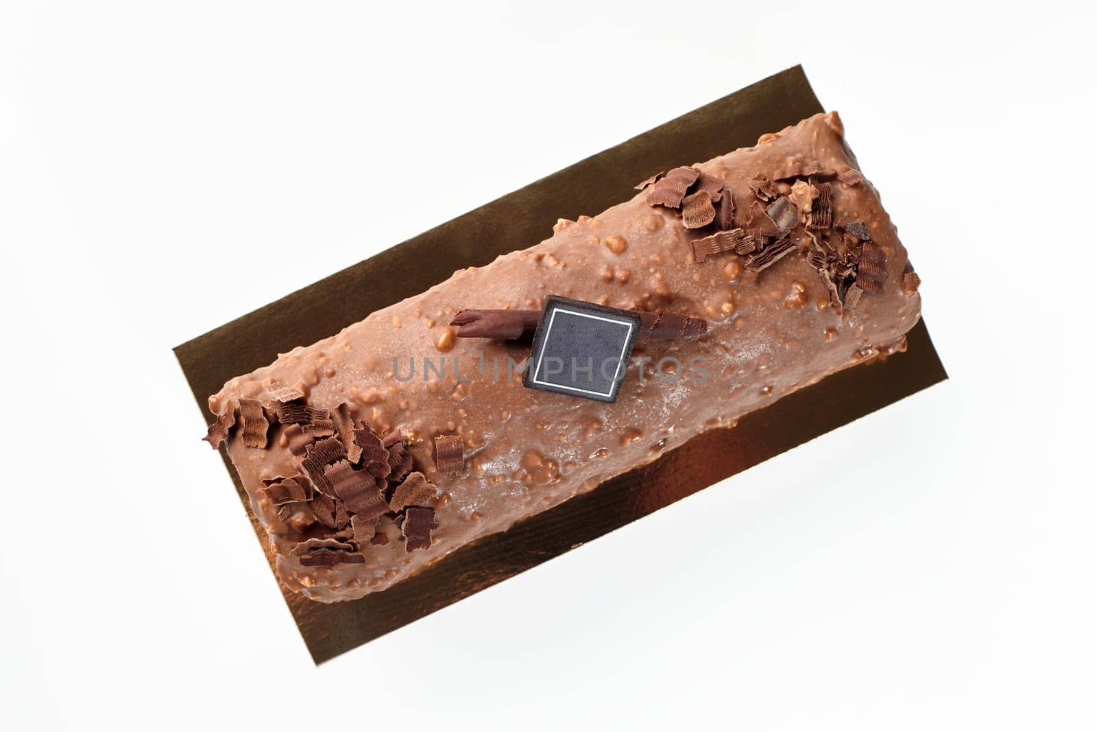 Artisan loaf cake glazed with milk chocolate icing and hazelnut crumbs isolated on white background, ideal for delicious snacking
