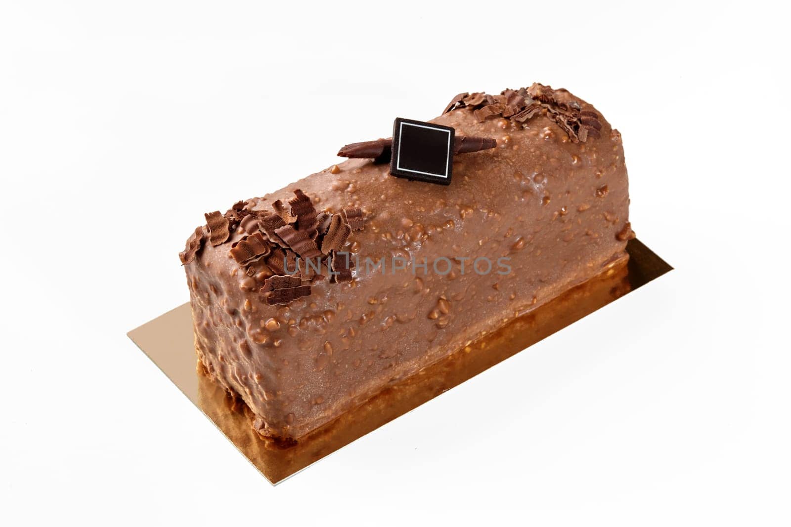 Delicious artisanal loaf cake coated with milk chocolate and nuts glaze, decorated with dark chocolate branding plaque on golden cardboard, isolated on white. Sweet pastries concept