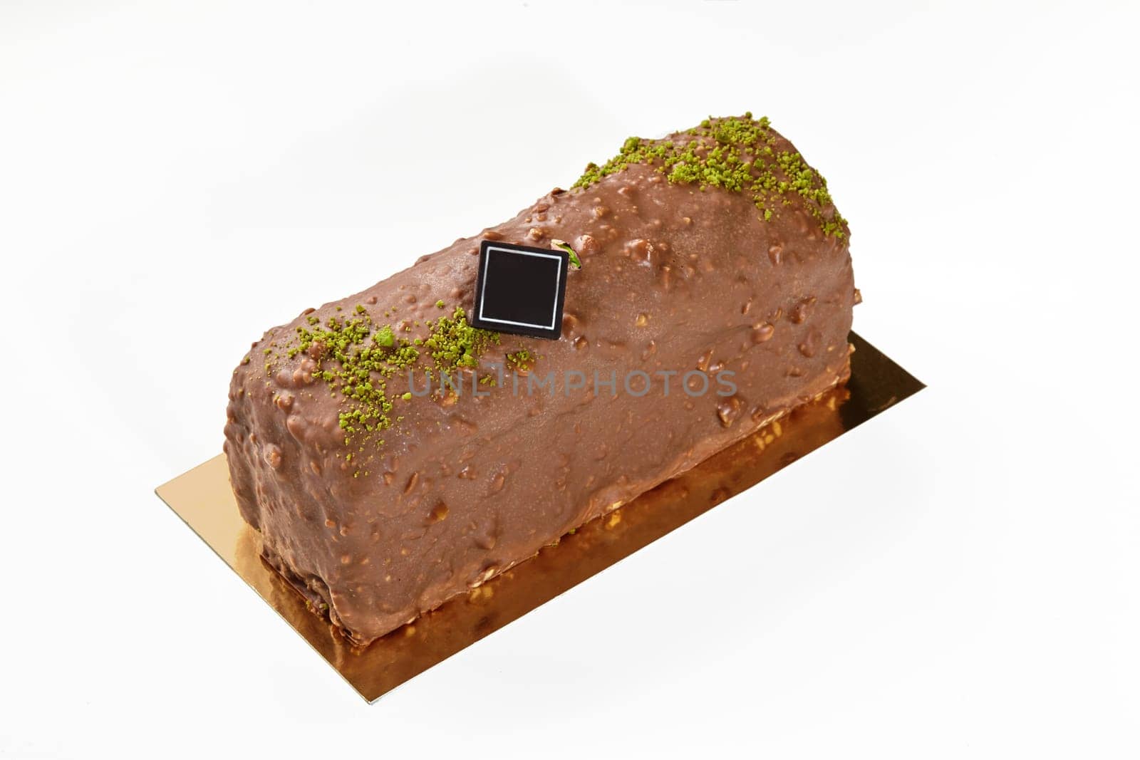 Handcrafted loaf cake glazed with milk chocolate and nut icing, sprinkled with pistachio crumbs, isolated on white background, ideal for delicious snacking