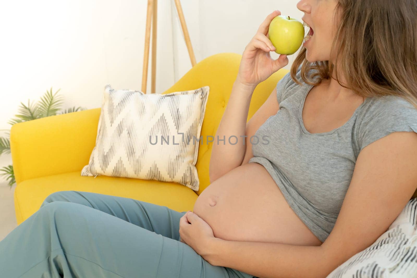 Unrecognizable pregnant woman eating healthy apple by PaulCarr