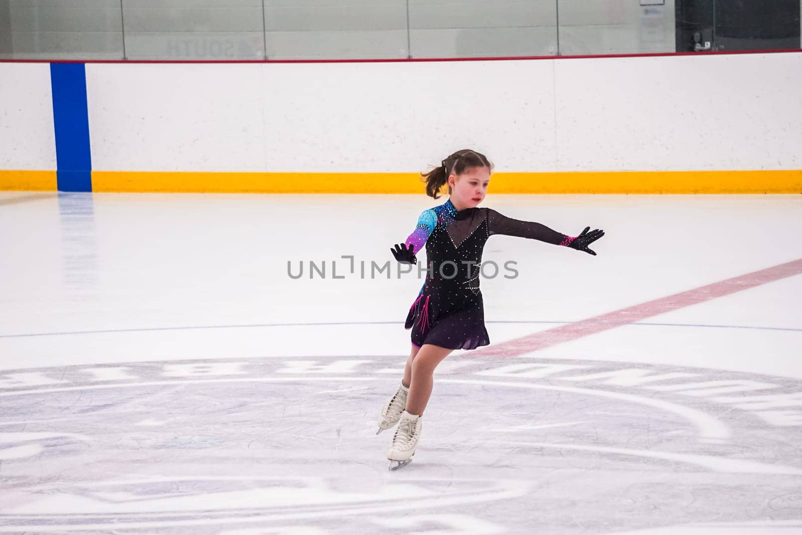 Little girl practicing before her figure skating competition at the indoor ice rink.