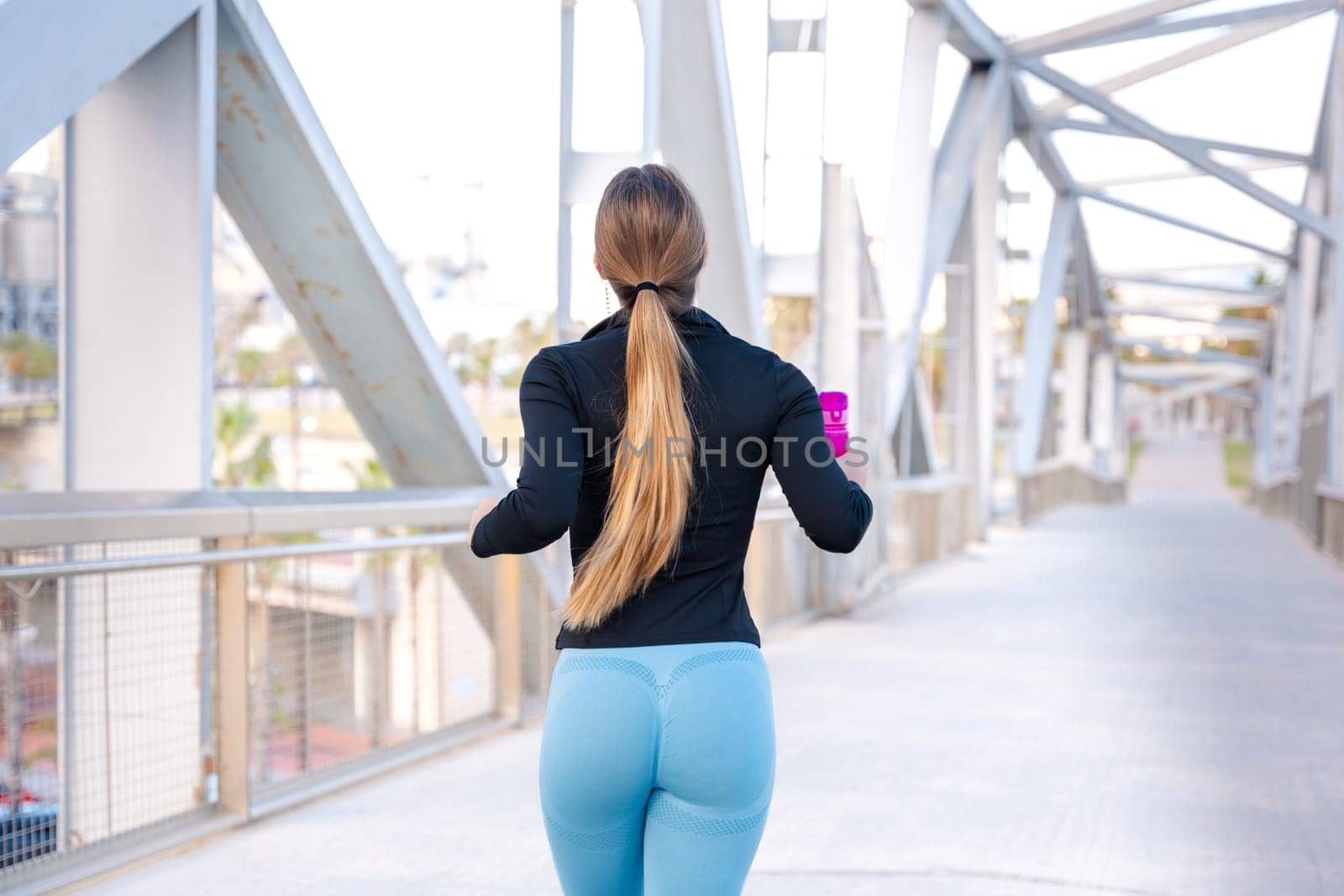 Fitness girl is running outdoors. Concept of workouts and healthy lifestyle.