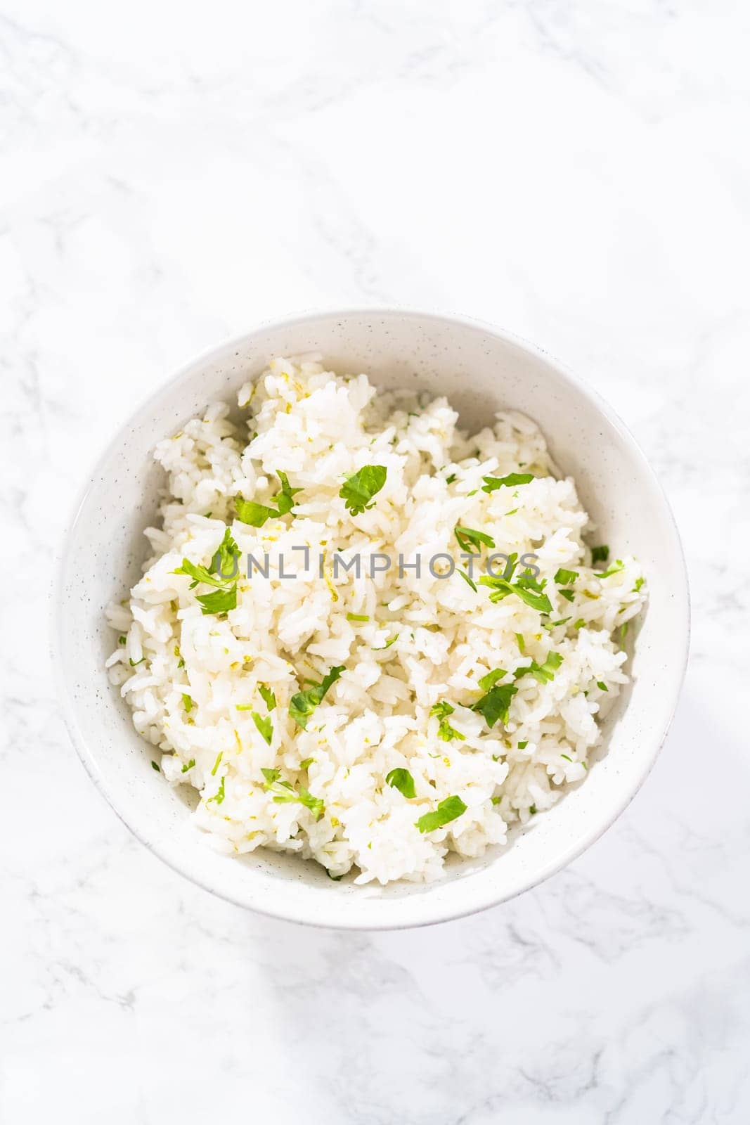 Cilantro Lime Rice. Serving cilantro lime rice garnished with fresh parsley in white ceramic bowls.
