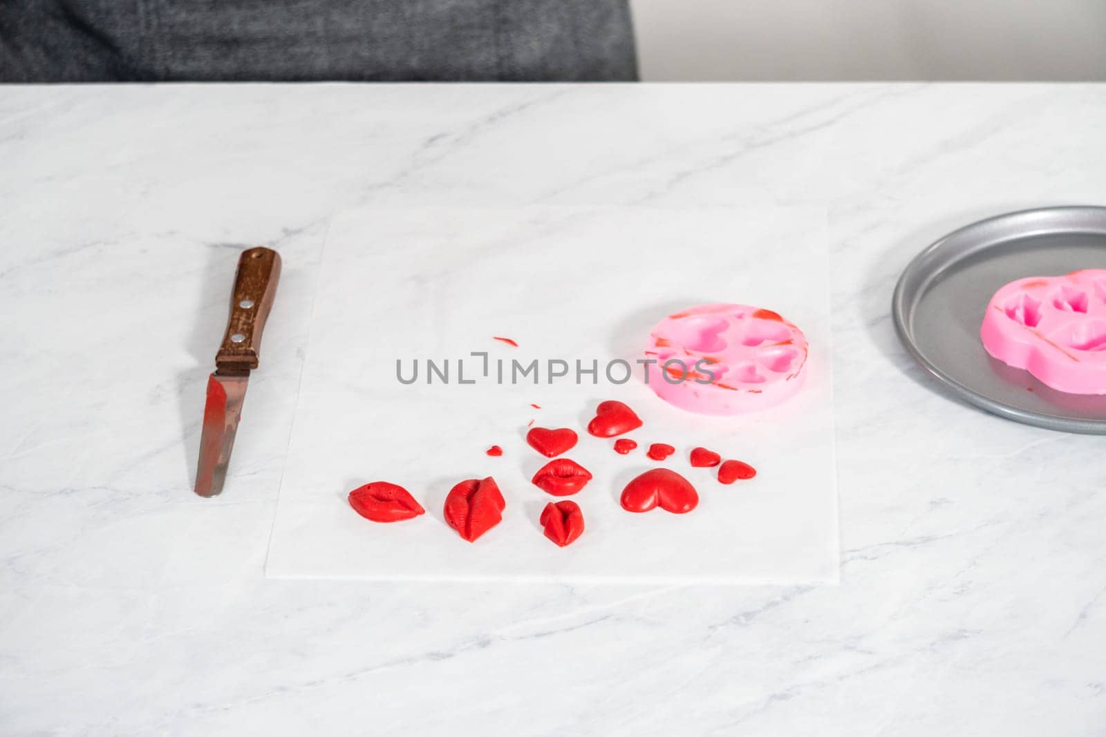 Dusting chocolate lips and heart-shaped chocolates with editable glitter for Valentine's Day.