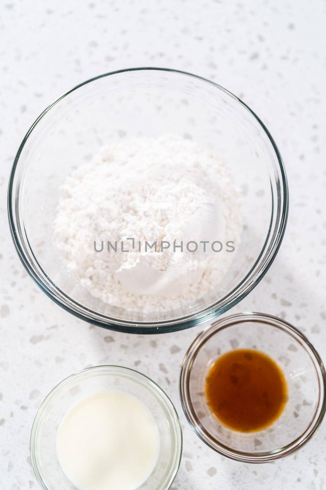 Measured ingredients in glass mixing bowls to make the vanilla glaze for bundt cake.