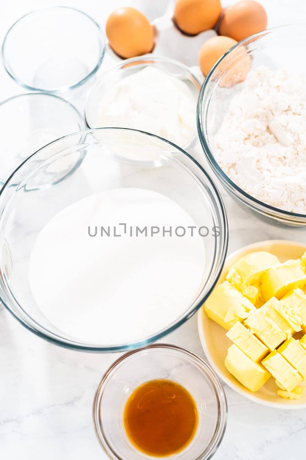 Measured ingredients in glass mixing bowls to bake red velvet bundt cake with cream cheese glaze.