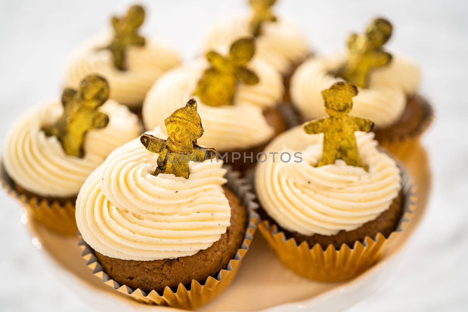 Freshly baked gingerbread cupcakes with eggnog buttercream frosting and topped with a gingerbread man.