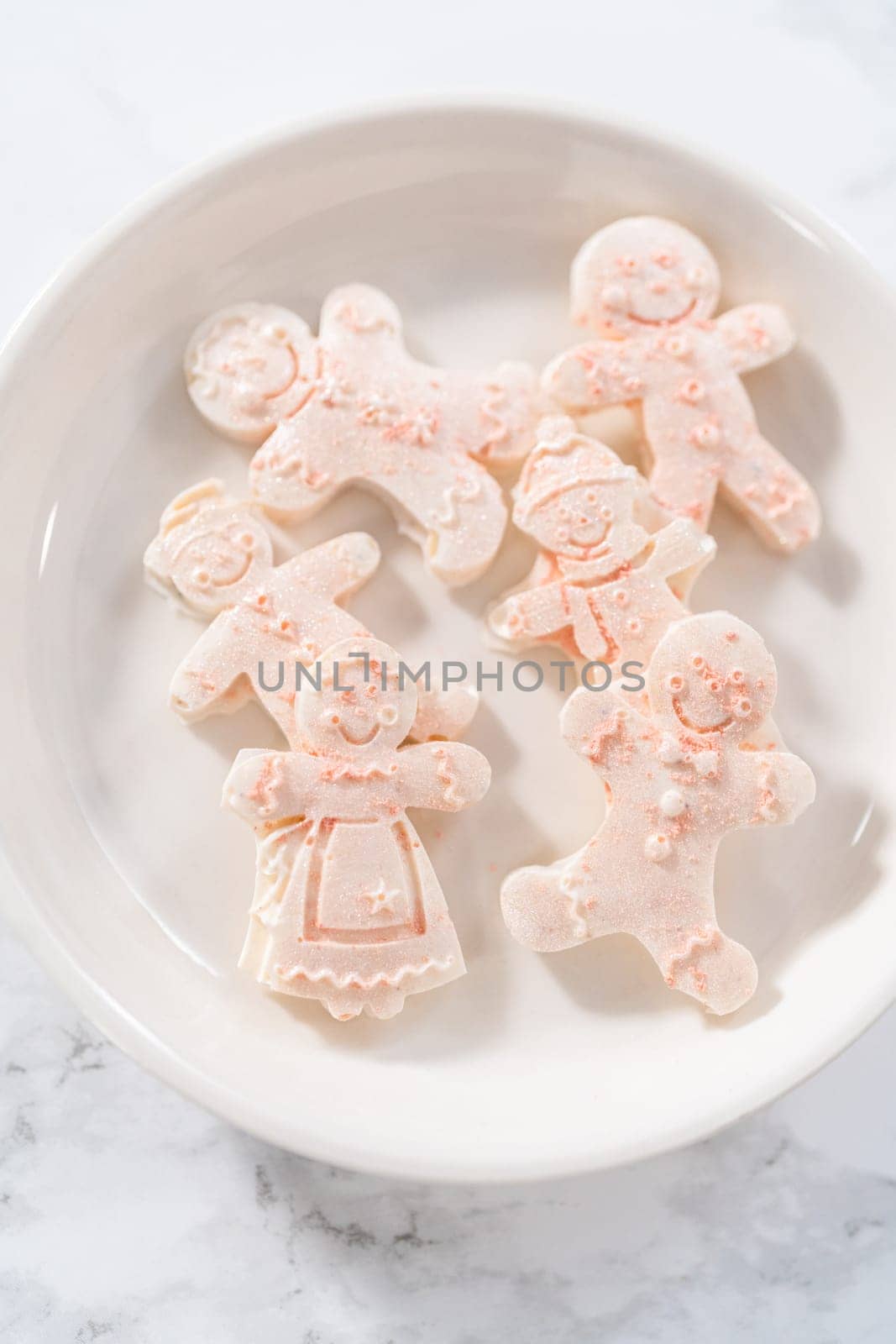 Chocolate gingerbread man with glitter on a white plate.