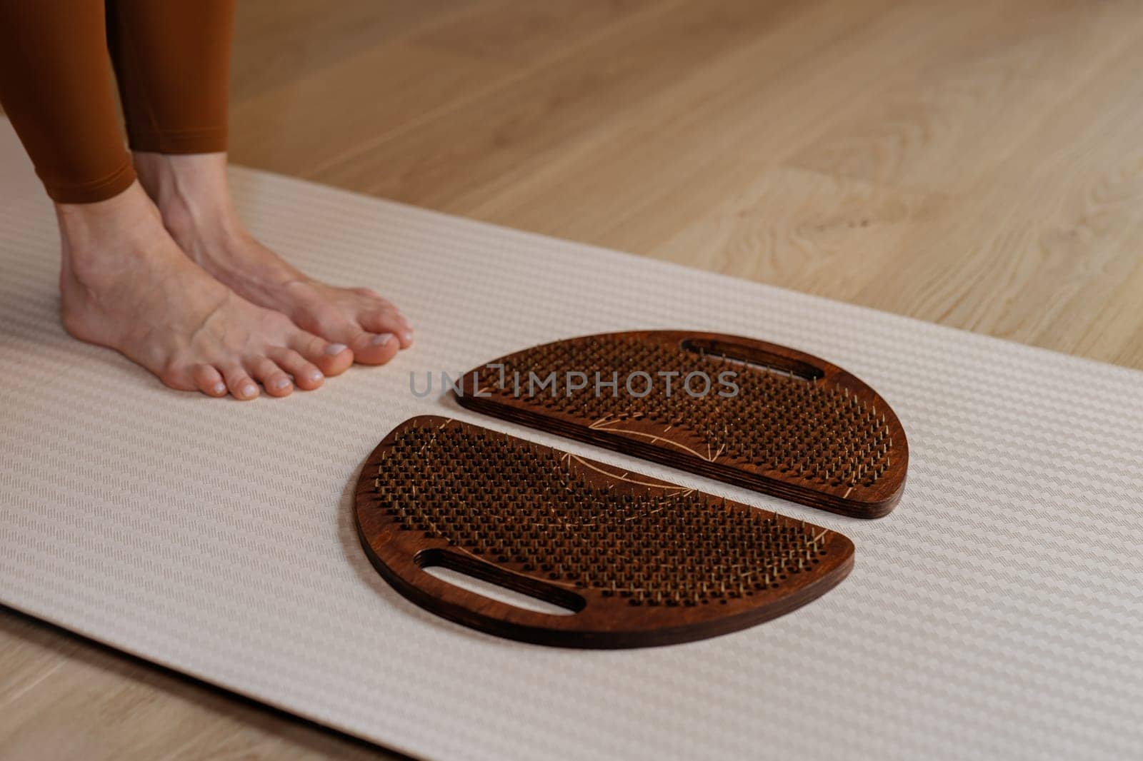 Anticipating the therapeutic touch, feet hover over sadhu boards on a calming yoga mat.