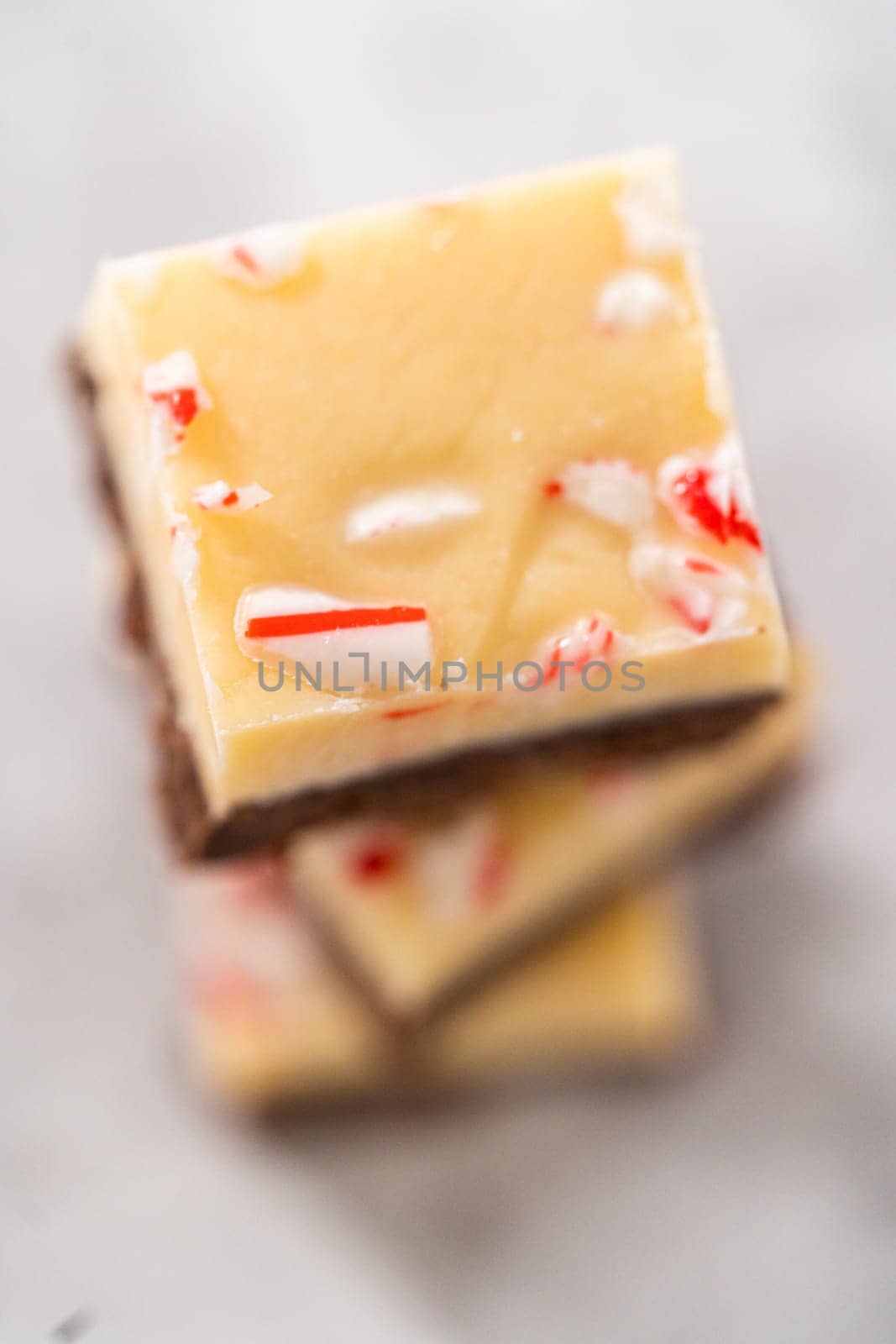 Homemade candy cane fudge square pieces on a kitchen counter.