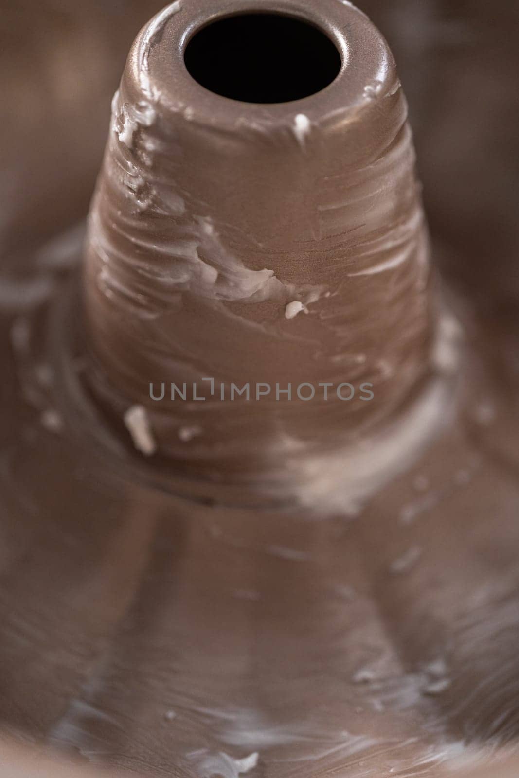 Greasing metal bundt cake pan to red velvet bundt cake with cream cheese glaze.