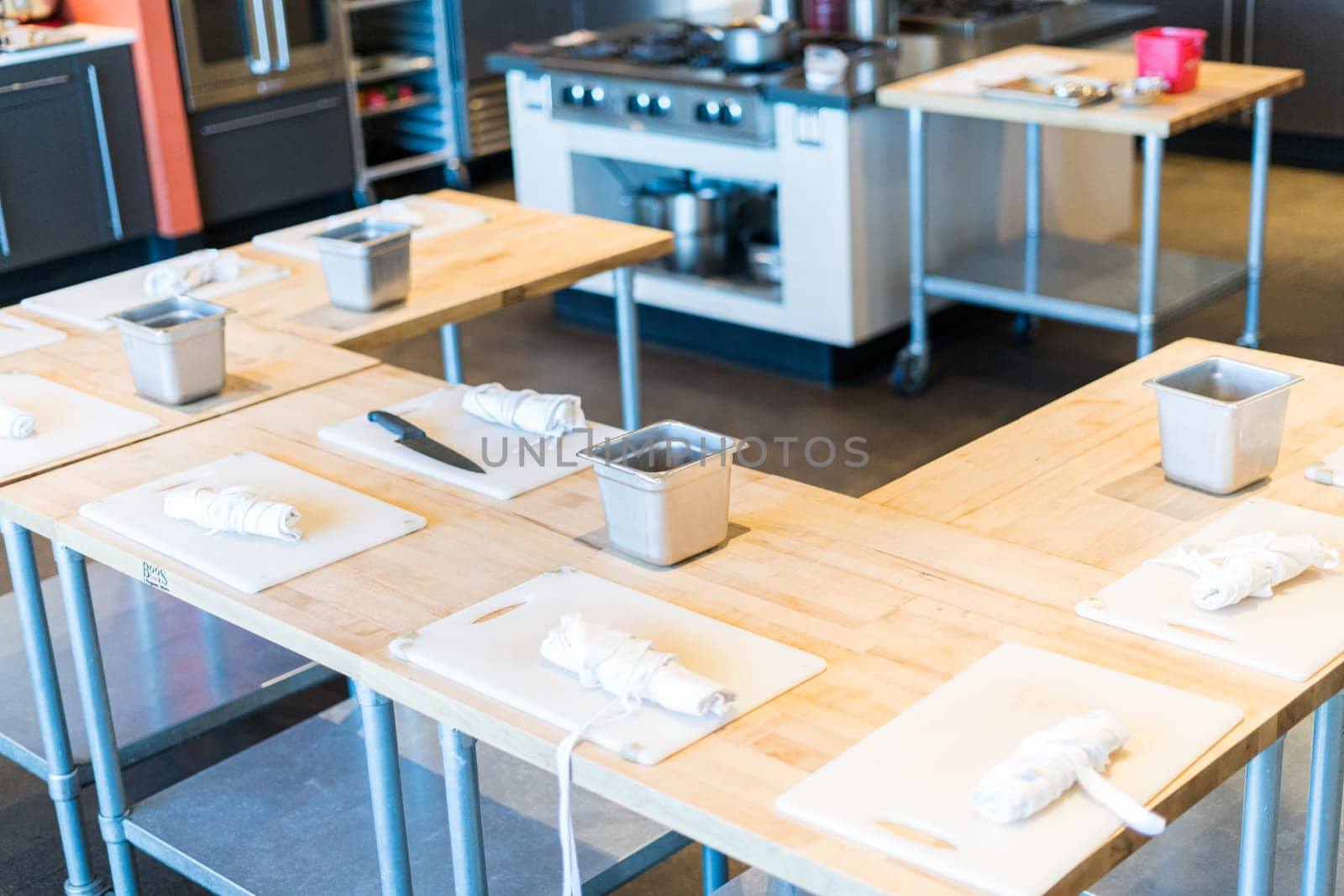 Tables prepared with white cutting boards and aprons for cooking class.