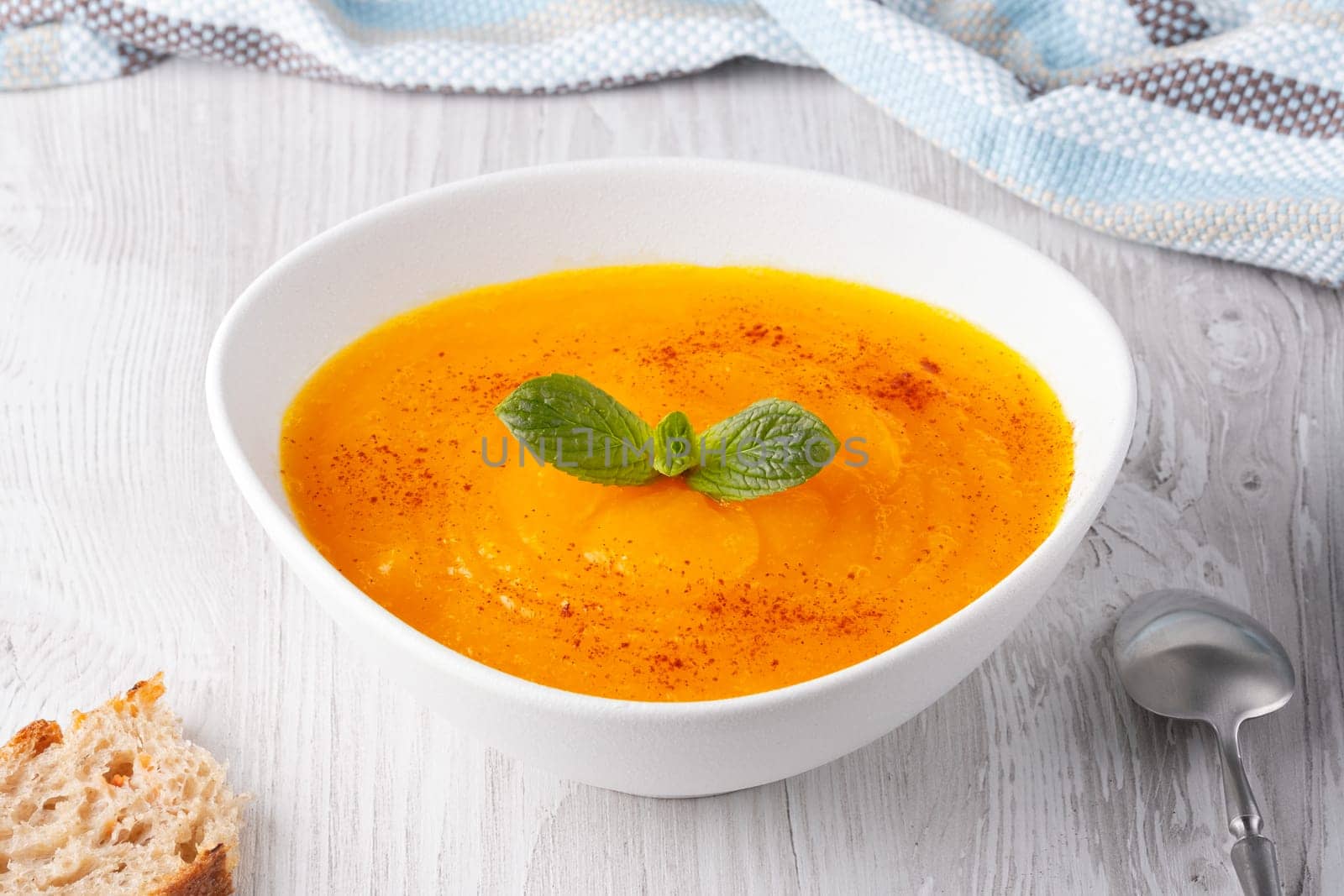 Pumpkin and carrot soup on white background.