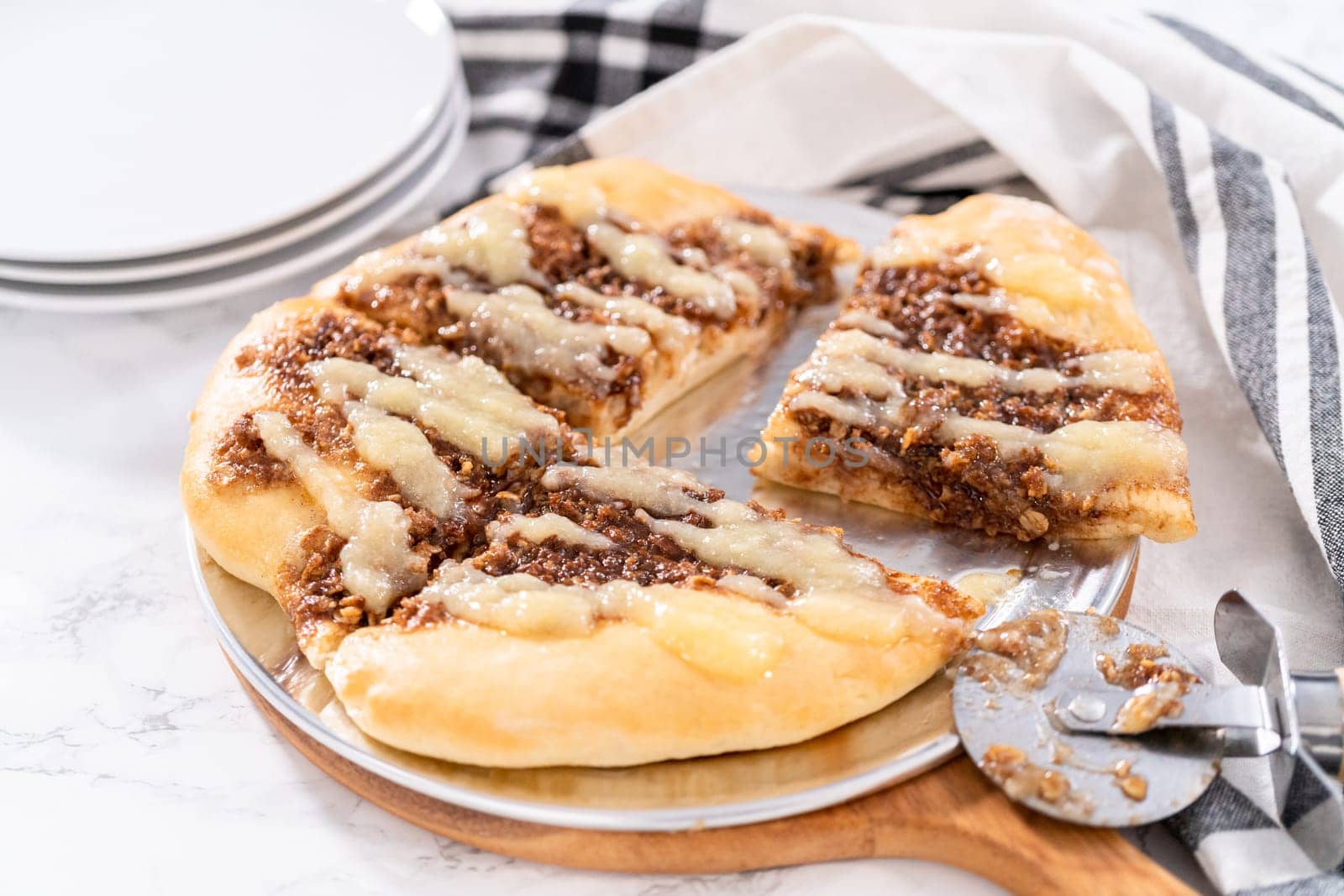 Freshly baked cinnamon dessert pizza with cream cheese drizzle.