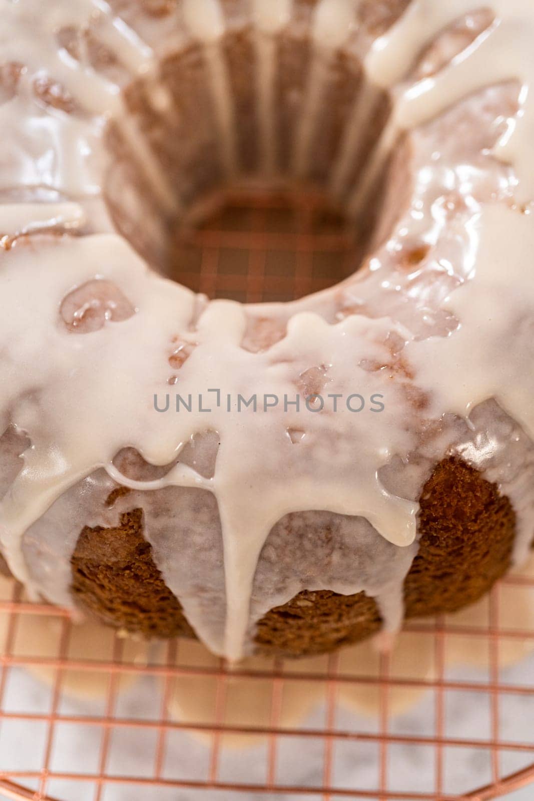Glazing vanilla bundt cake with a white vanilla glaze.