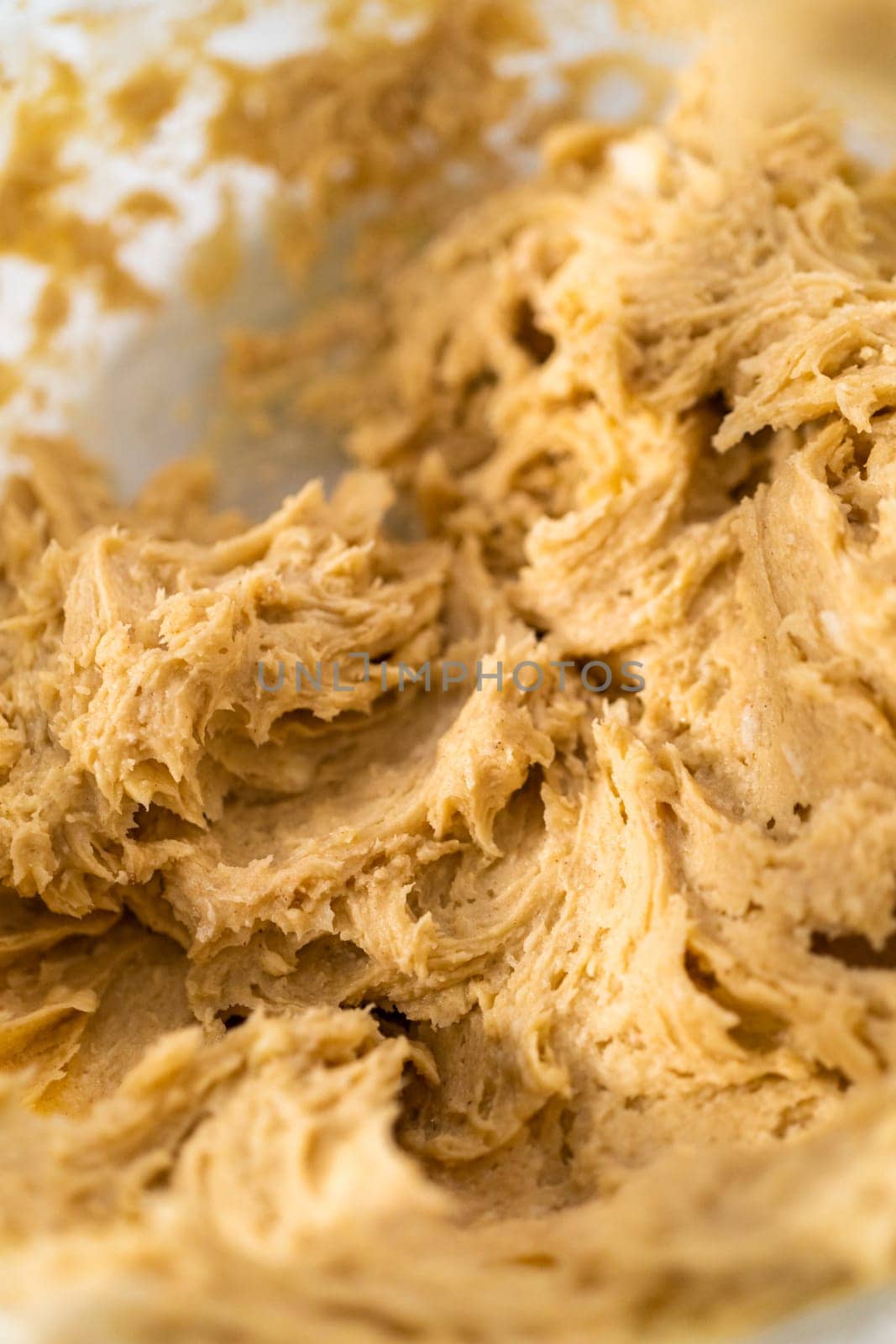 Mixing ingredients with a hand mixer to bake eggnog cookies with a chocolate gingerbread man.