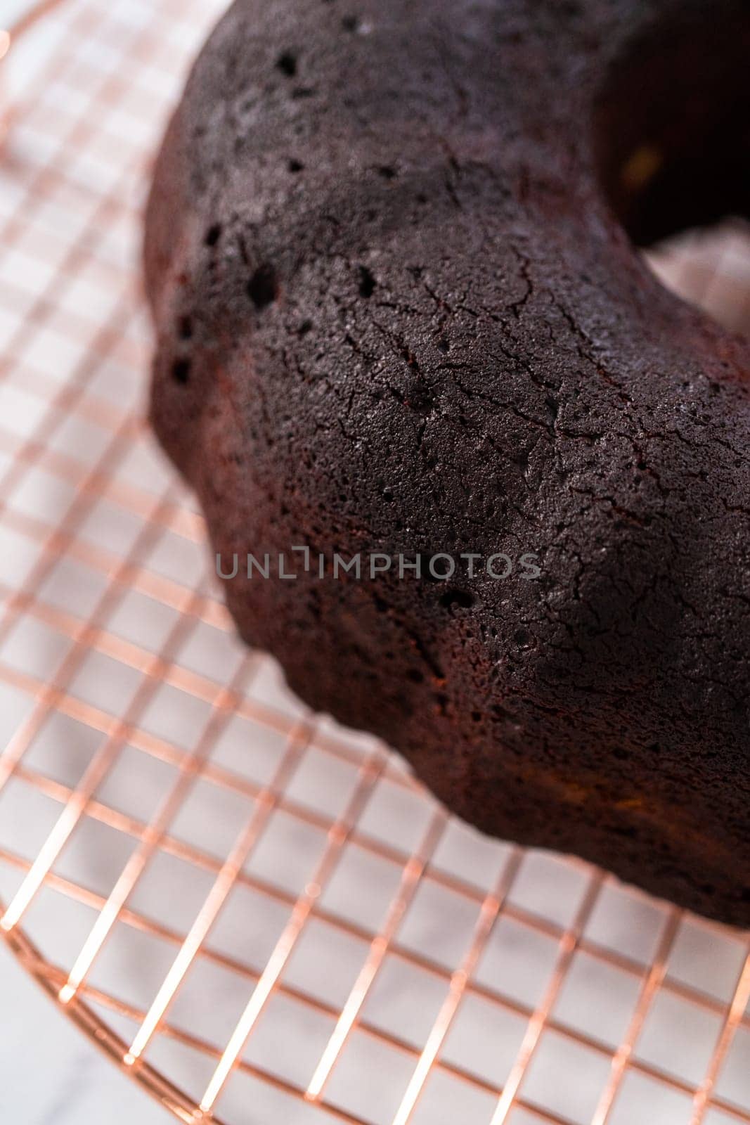 Cooling freshly baked red velvet bundt cake on a kitchen counter.