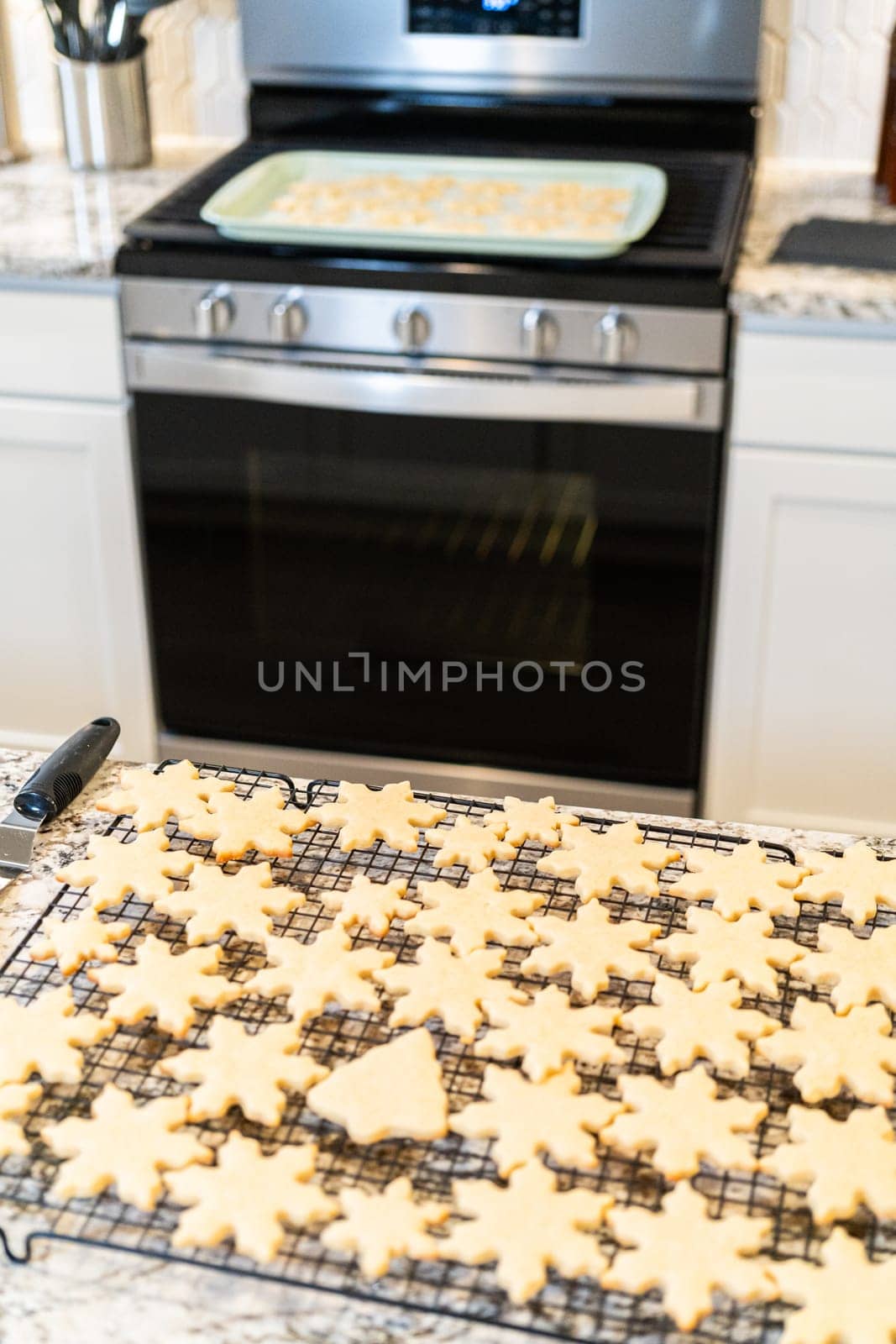 Cooling Snowflake-Shaped Sugar Cookies on a Rack by arinahabich