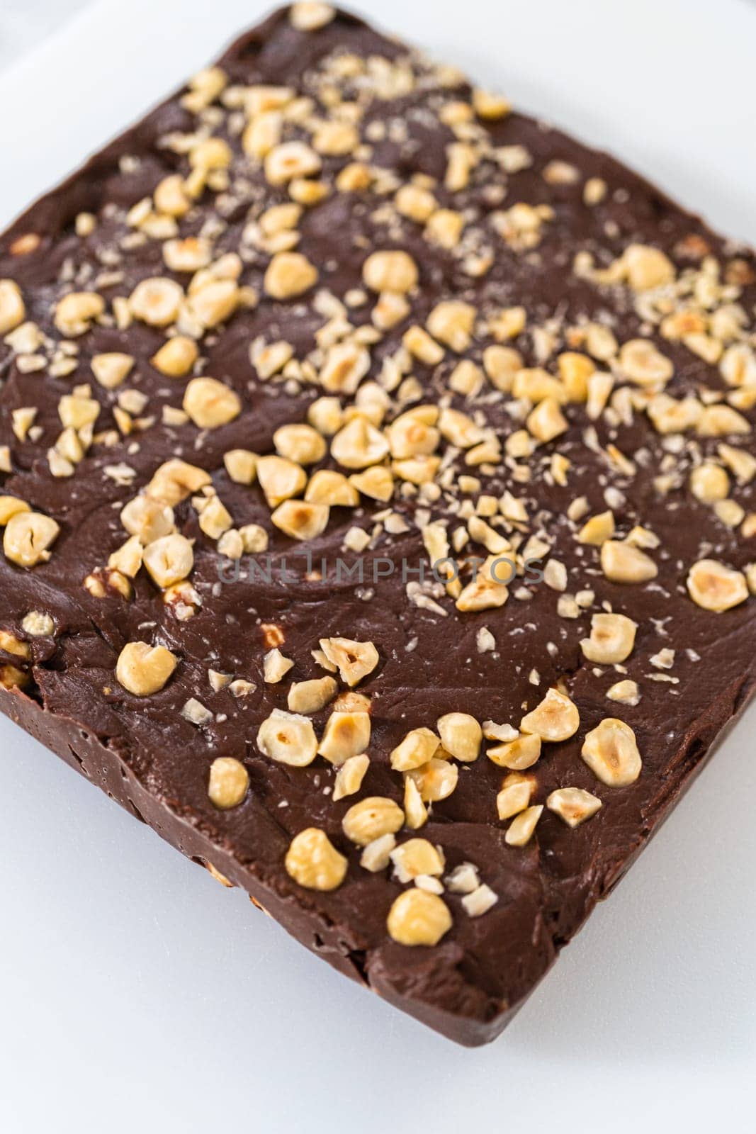 Scoring chocolate hazelnut fudge using a wheel dough cutter for cutting into small square pieces.