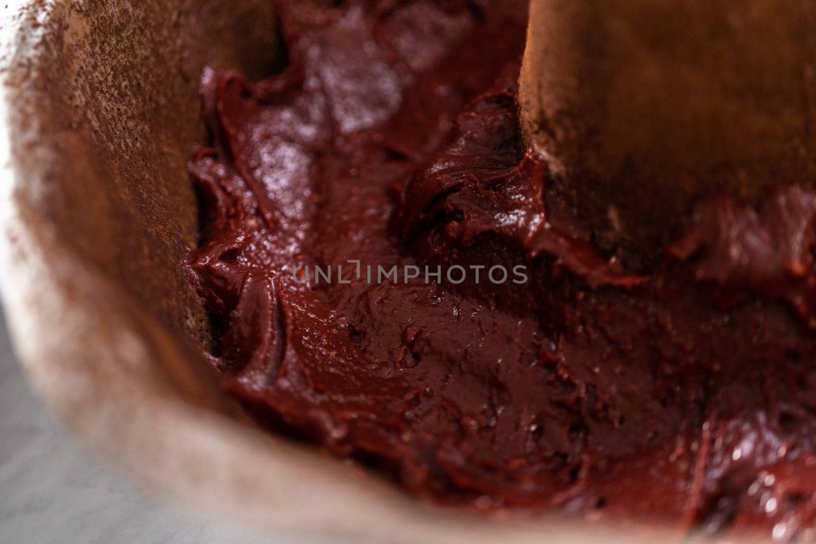 Filling metal bundt cake pan with cake butter to bake red velvet bundt cake with cream cheese glaze