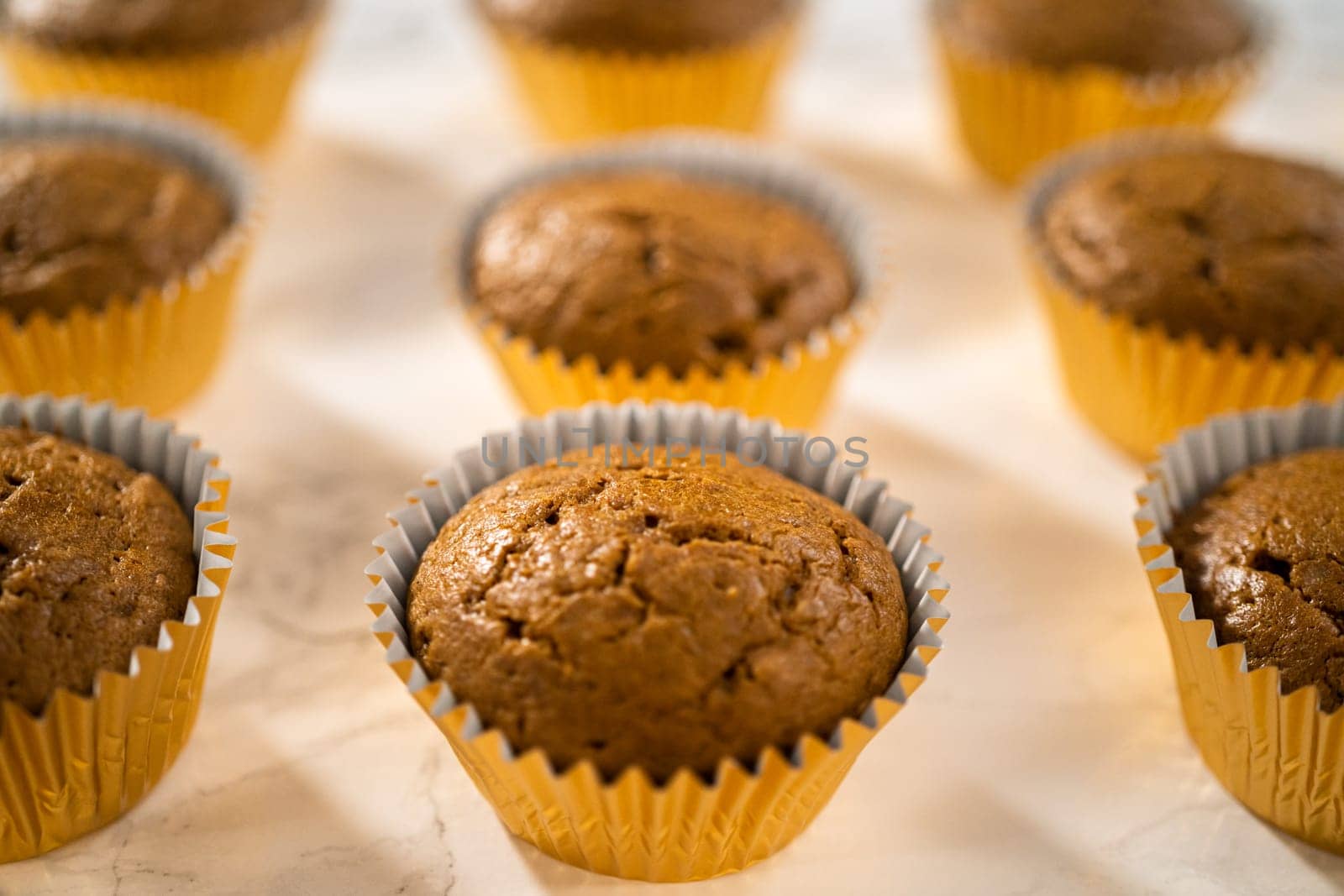 Cooling freshly baked gingerbread cupcakes on a kitchen counter.