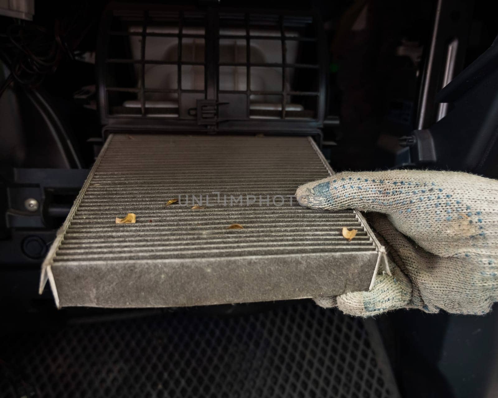 A mechanic changes the cabin air filter of a car