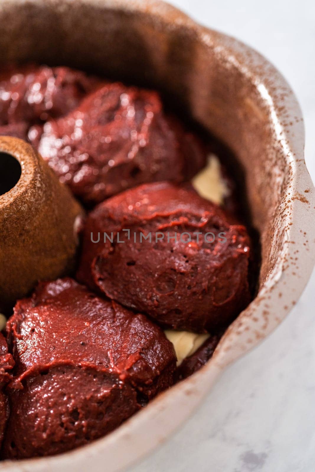 Filling metal bundt cake pan with cake butter to bake red velvet bundt cake with cream cheese glaze