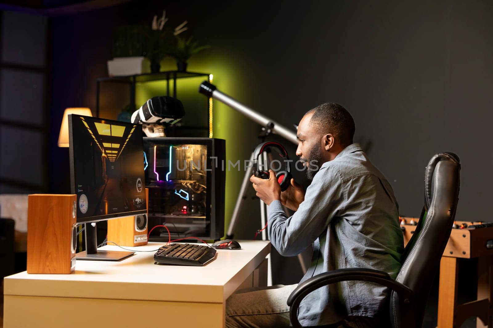 Gamer putting headphones on to play science fiction first person shooter videogame at home and hear gun sounds. BIPOC person enjoying futuristic coop FPS game with friends, chatting online