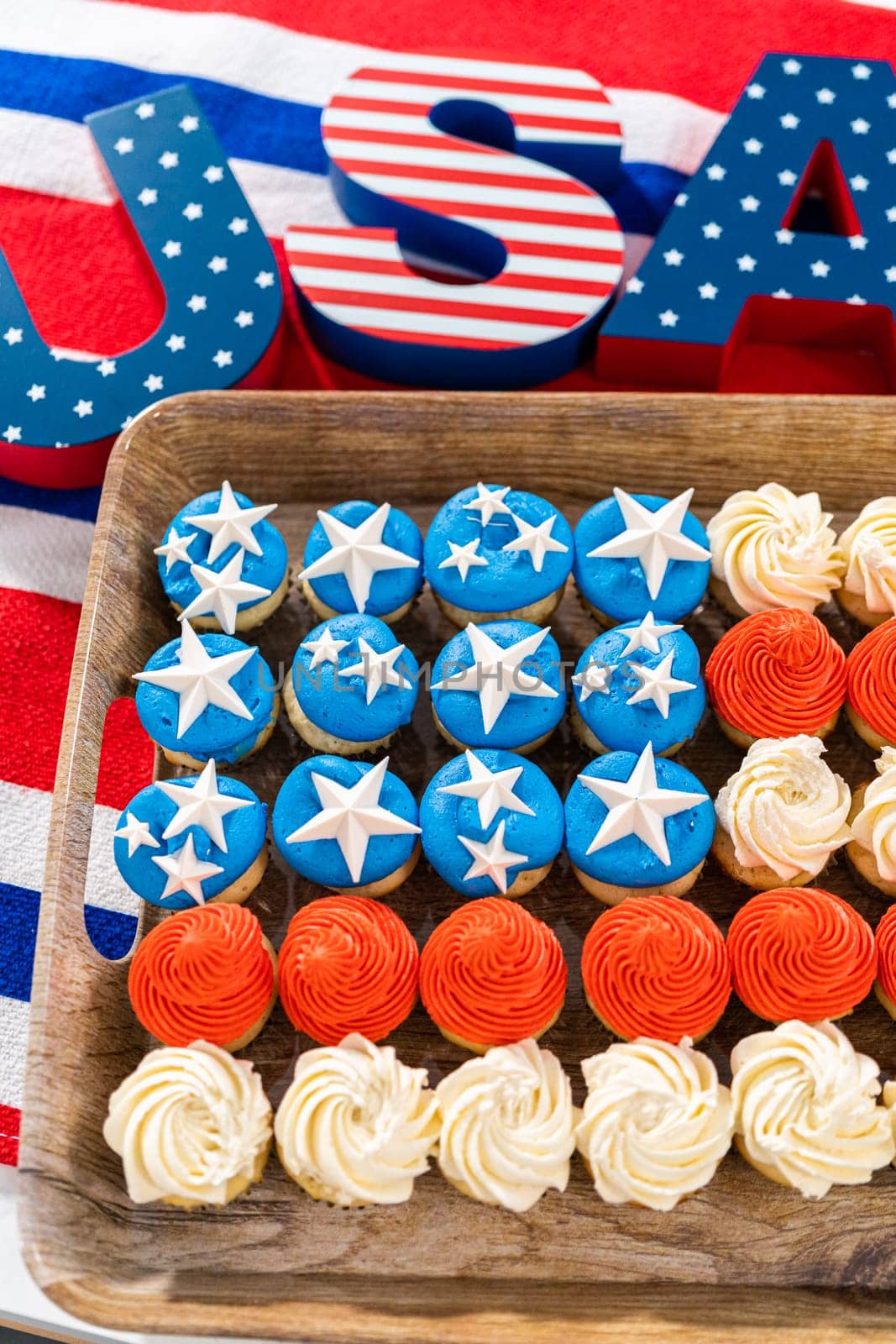 Arranging mini vanilla cupcakes in the shape of the American flag.